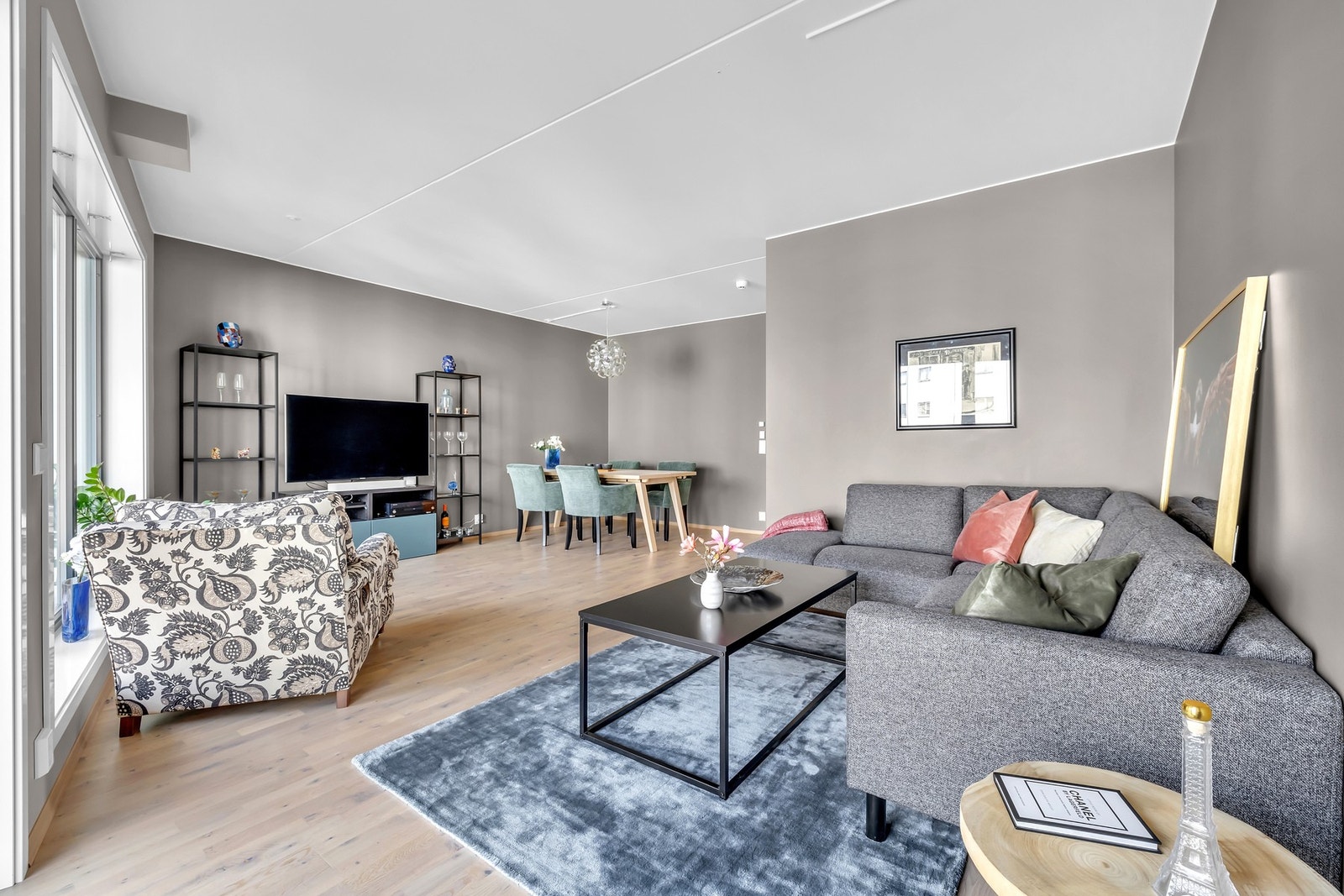 De store vindusflatene kombinert med de tidsriktige malte flatene gjør at rommet oppleves som et lunt og behagelig oppholdsrom. Galleribilde