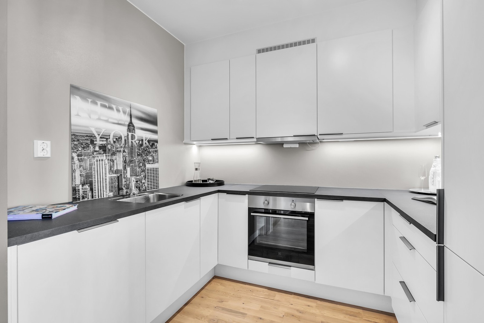 Integrerte hvitevarer med innfelt platetopp i benkeplate, oppvaskmaskin, komfyr og kjøl/frys. Galleribilde