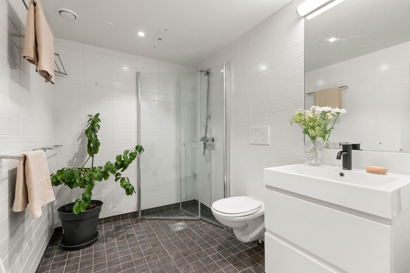 Badet har et tidløst og funksjonelt design, med flislagt gulv og vegger. Galleribilde