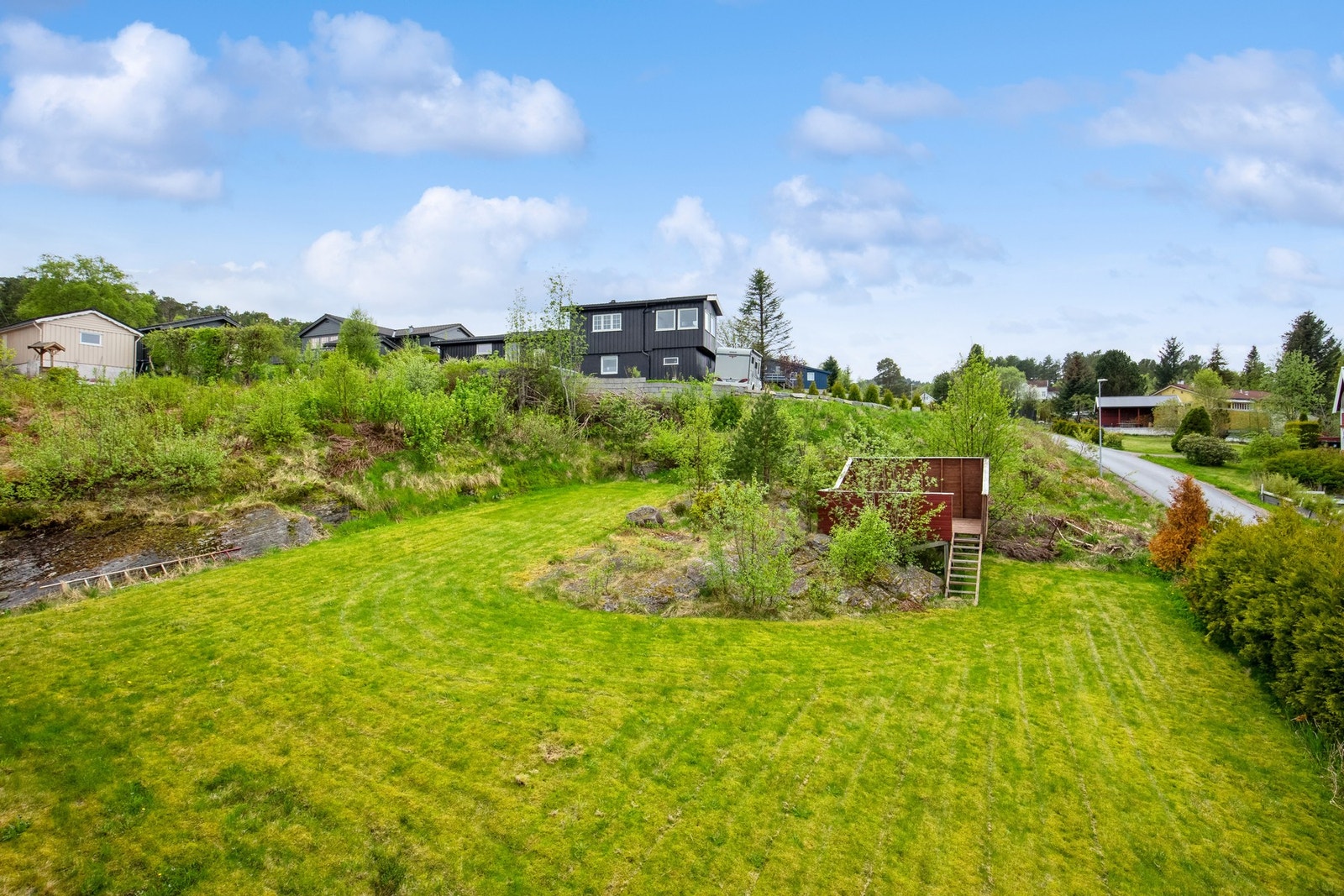 Tomten er opparbeidet med plen og beplantninger Galleribilde