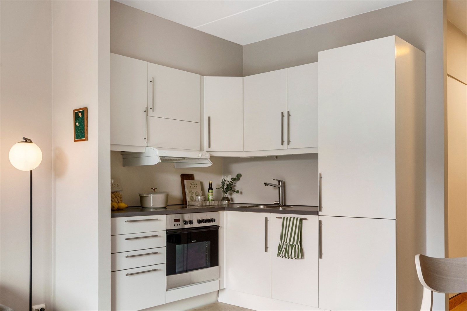 Kjøkkenet er moderne og stilrent, med godt med skapplass og arbeidsflater for matlaging. Galleribilde