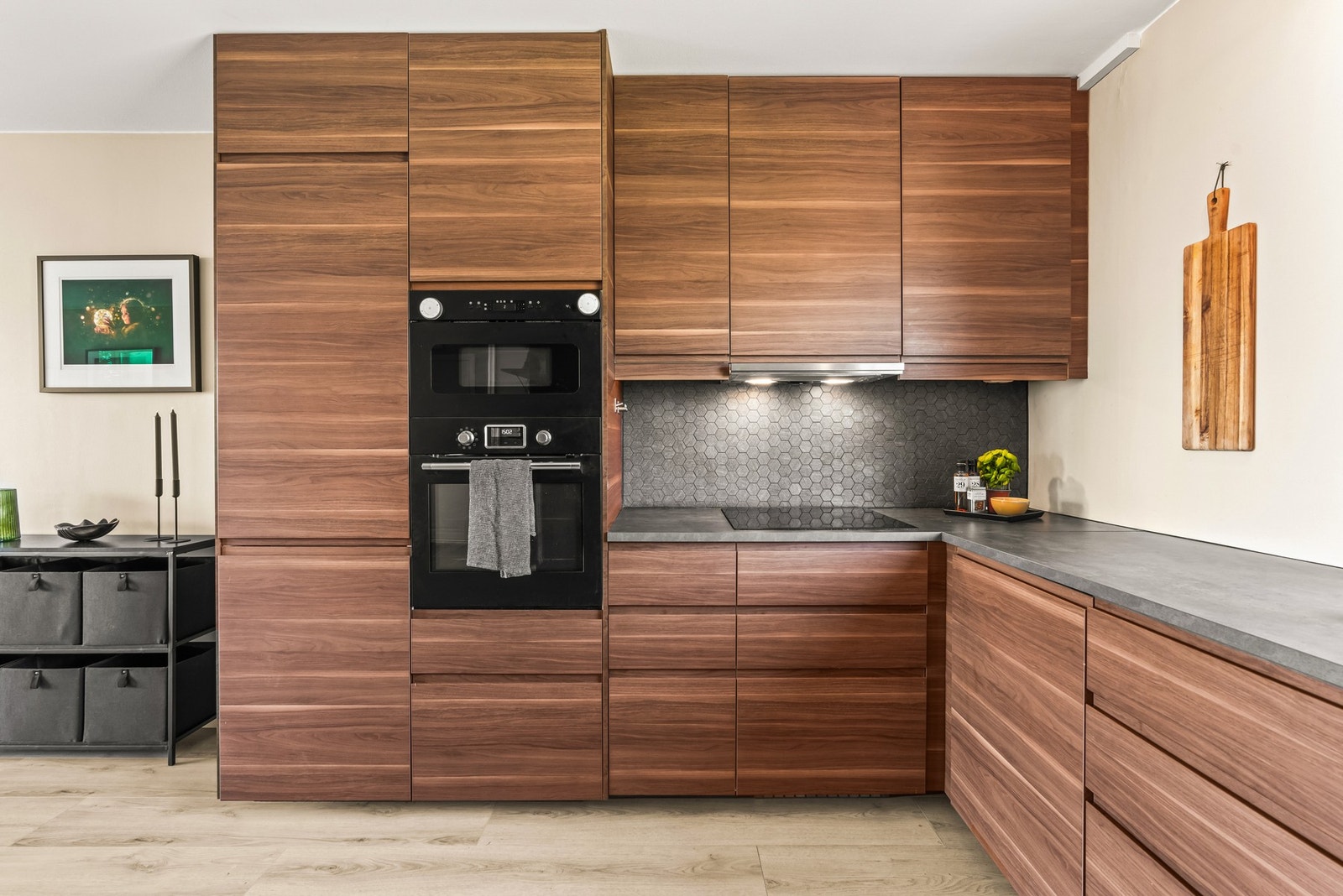 Innredningen fra IKEA med overskap som strekker seg helt til tak, og over benken er veggene kledd med grå hexagon-fliser som harmonerer godt med resten av interiøret. Galleribilde