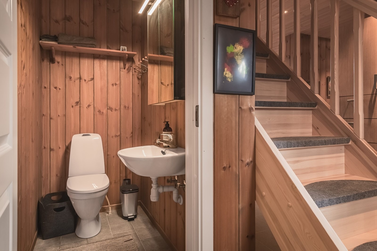 Fra entréen er det også adkomst til et praktisk ekstra toalettrom. Toalettrommet har flislagt gulv med gulvvarme, trepanel på veggene og avtrekksvifte. Galleribilde