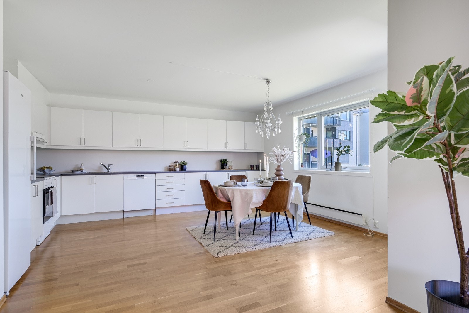 Leiligheten fremstår luftig med åpen løsning til kjøkkenet, noe som inviterer til en sosial hverdag Galleribilde