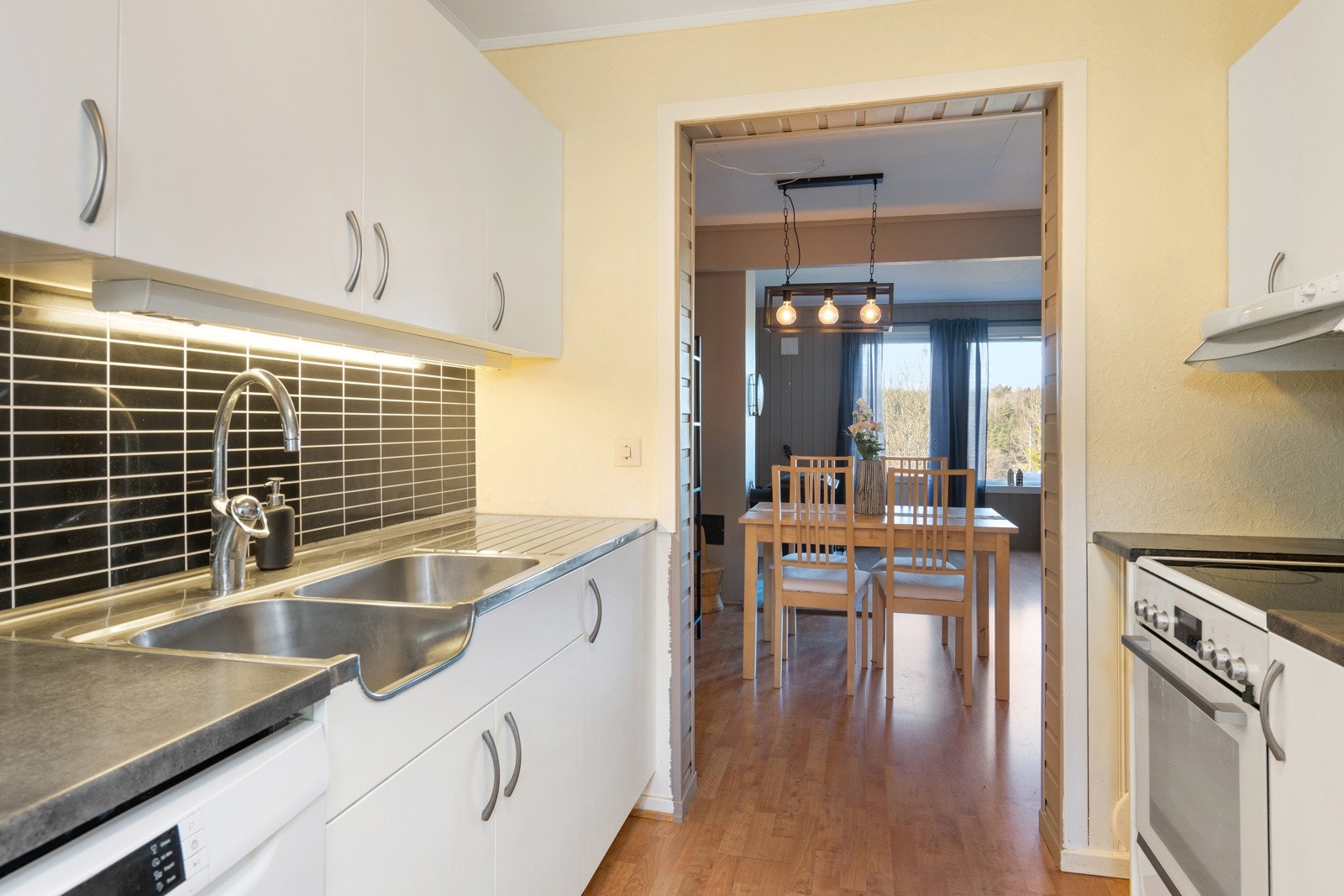 Kjøkkeninnredning med glatte fronter og laminat benkeplate. Galleribilde