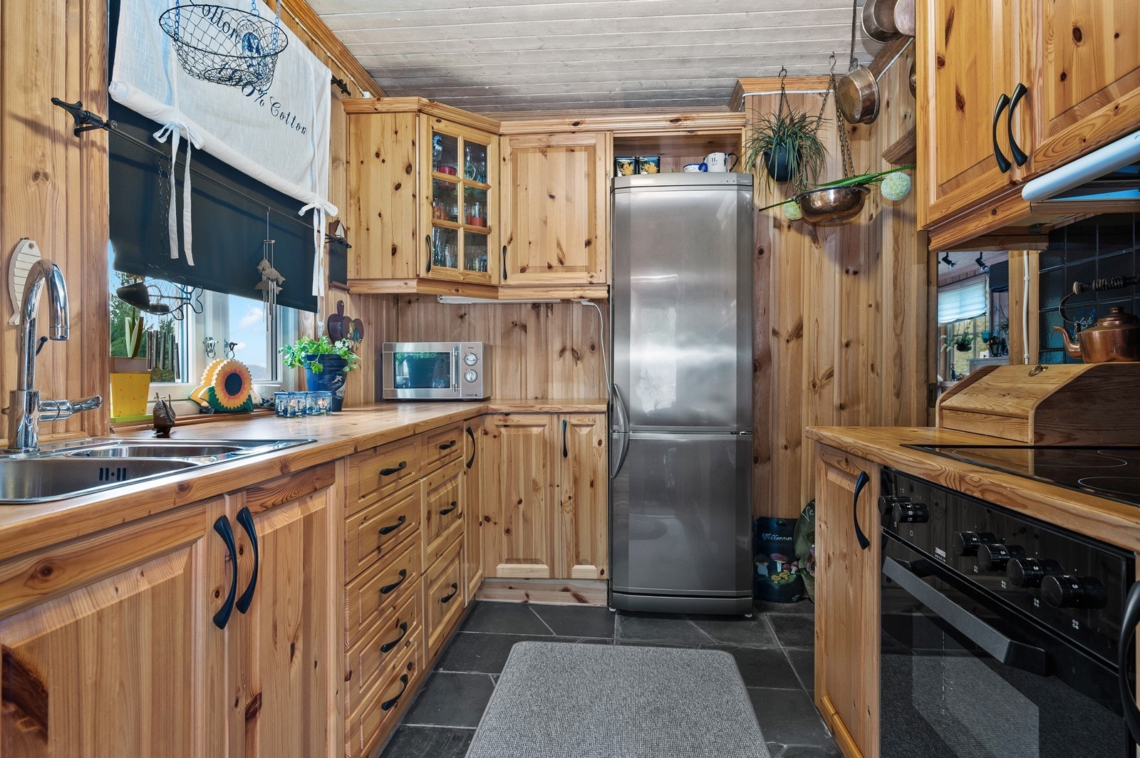 Kjøkkenet har furu innredning med profilerte fronter og laminat benkeplate Galleribilde