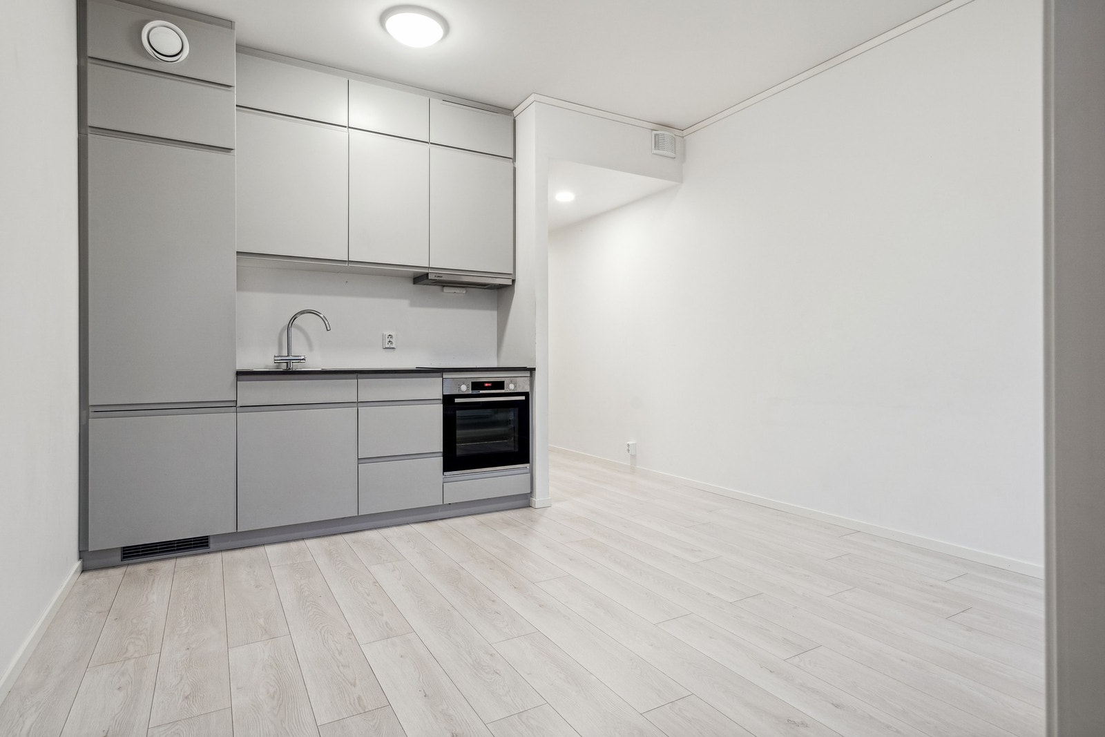 Tidløs og moderne kjøkkeninnredning med kjøle- og fryseskap, platetopp og stekeovn fra Bosch. Galleribilde