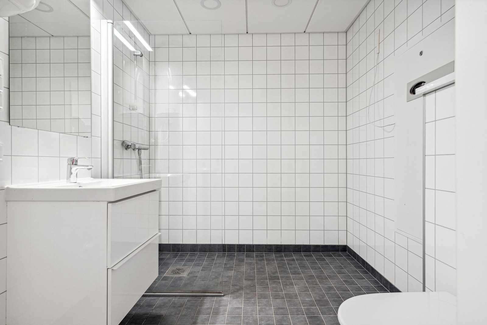 Tidløs bad med våtromsplater på vegger og fliser på gulvet. Selve leiligheten har vannbåren varme i alle rom. Det er opplegg for vaskemaskin i rommet. Galleribilde