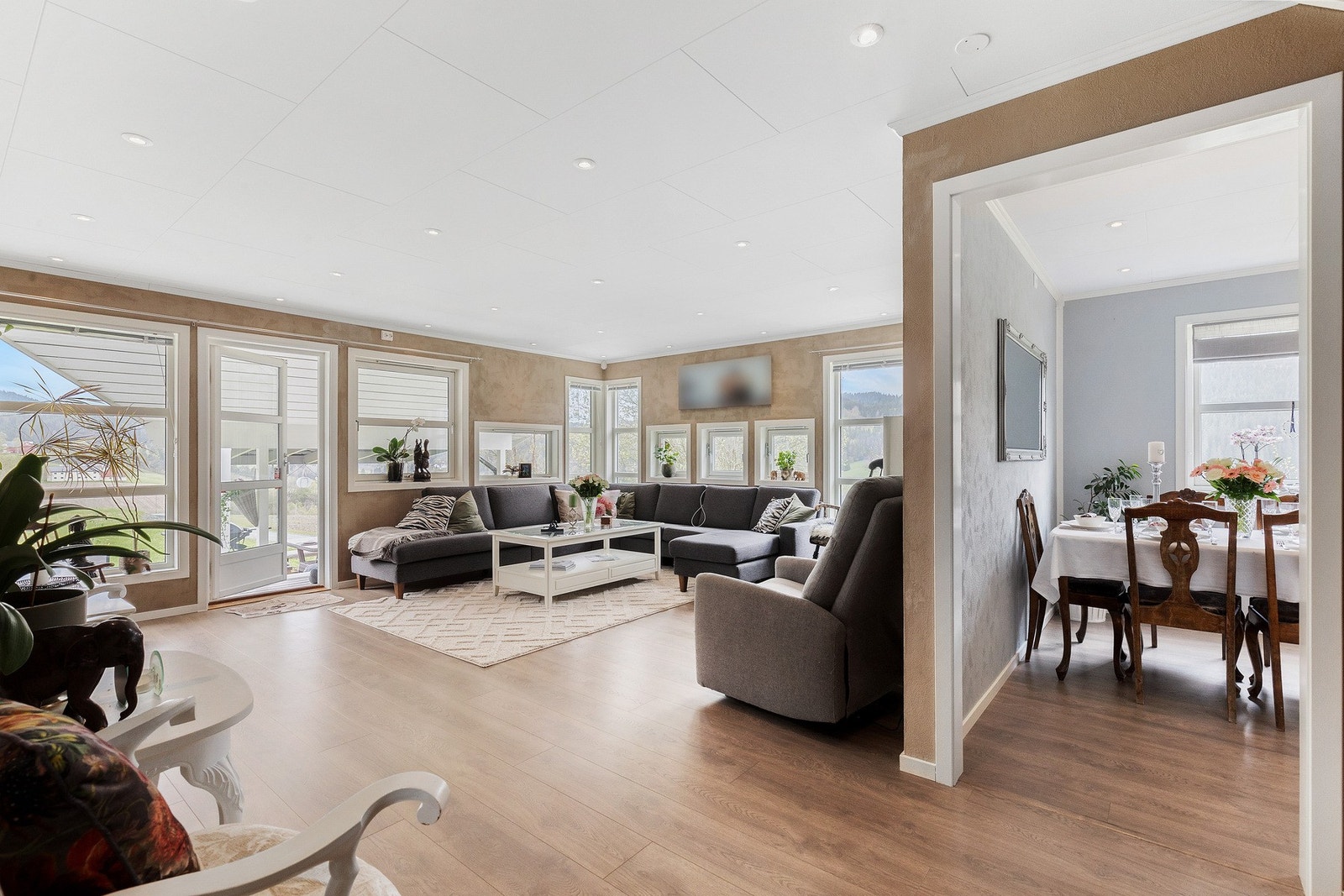 Stort og romslig stue på 33 kvm med et moderne preg, utstrakt bruk av downlights i tak og behagelig gulvvarme fra varmefolie i gulv. Galleribilde