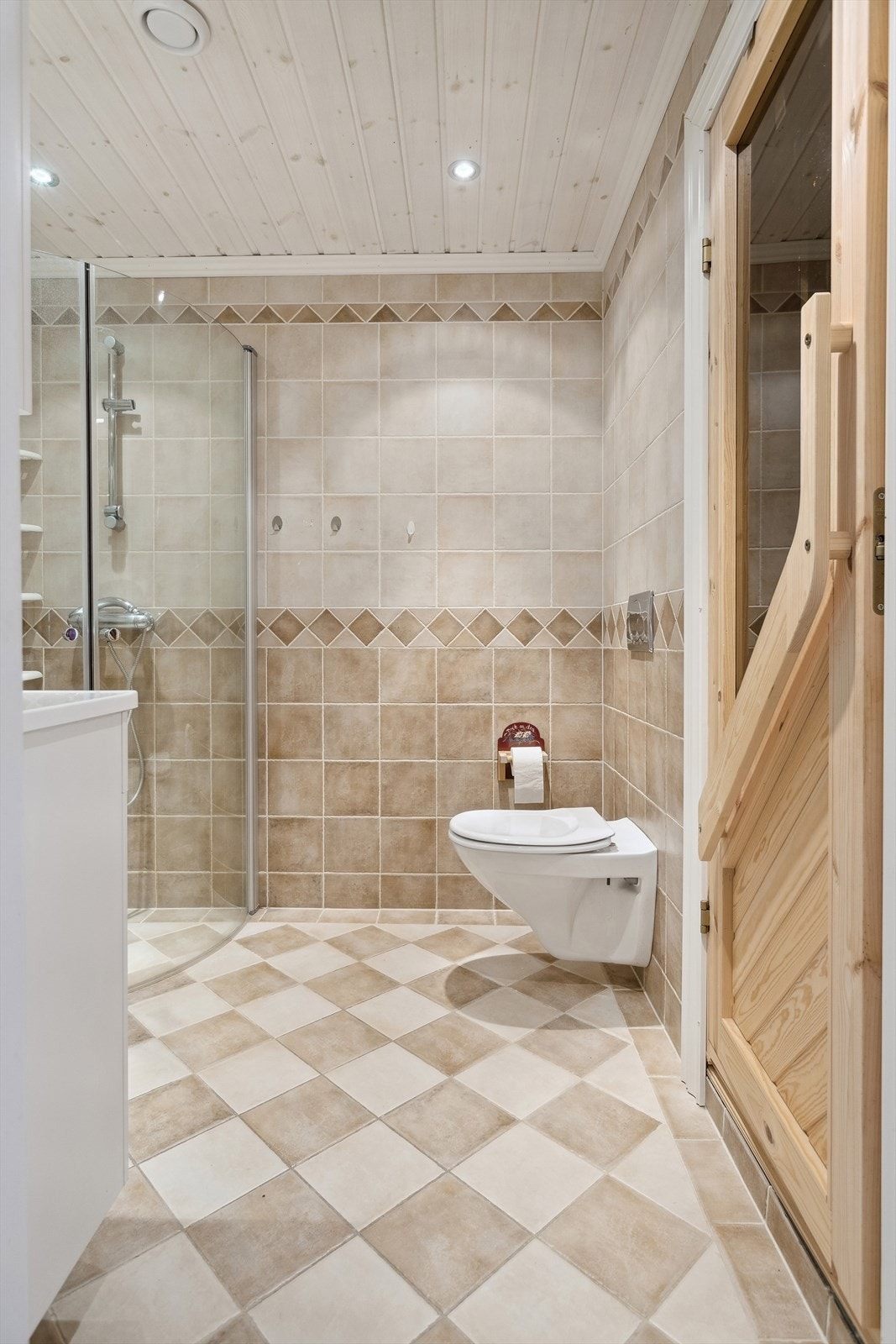 Baderom 1 er et lyst og pent baderom fra byggeåret 2007. Baderommet har tidløse fliser på gulv og vegger, deilig gulvvarme og downlights i himlingen. Fra baderommet har du også adkomst til badstue med flislagt gulv og overflater med panel. Galleribilde