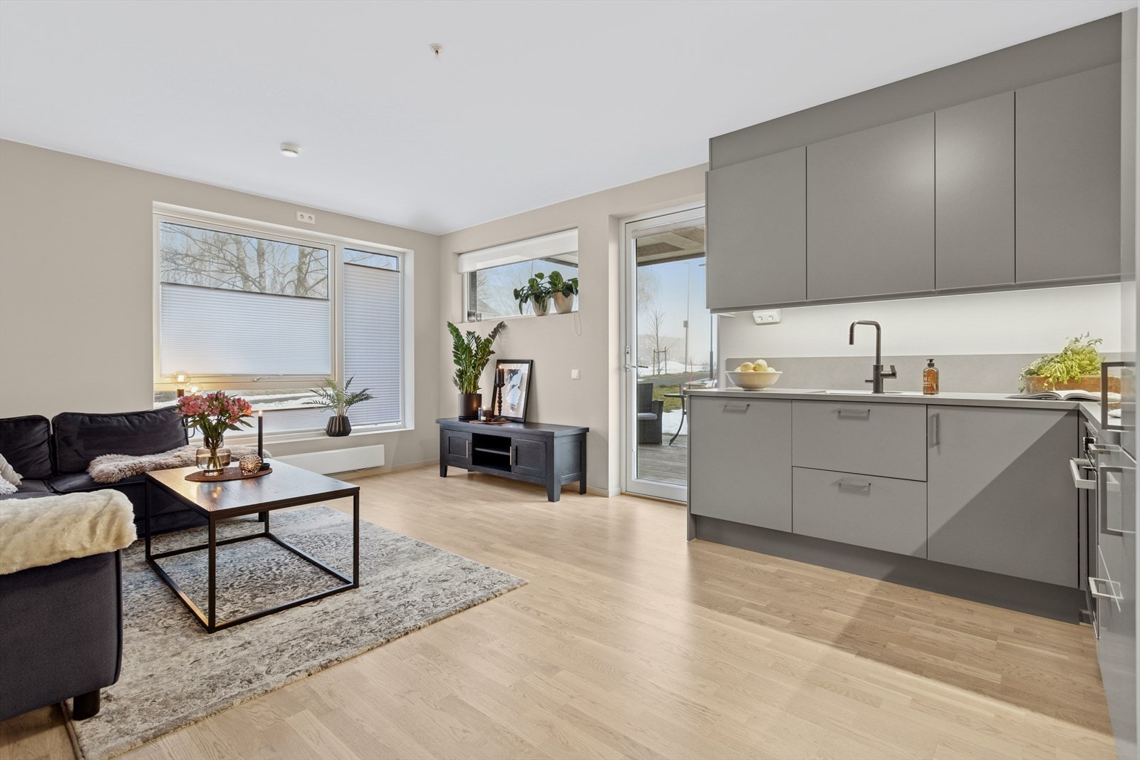 Store flotte vinduer gir god naturlig belysning gjør at leiligheten oppleves som lys og trivelig. Her med montert plissegardiner. Galleribilde