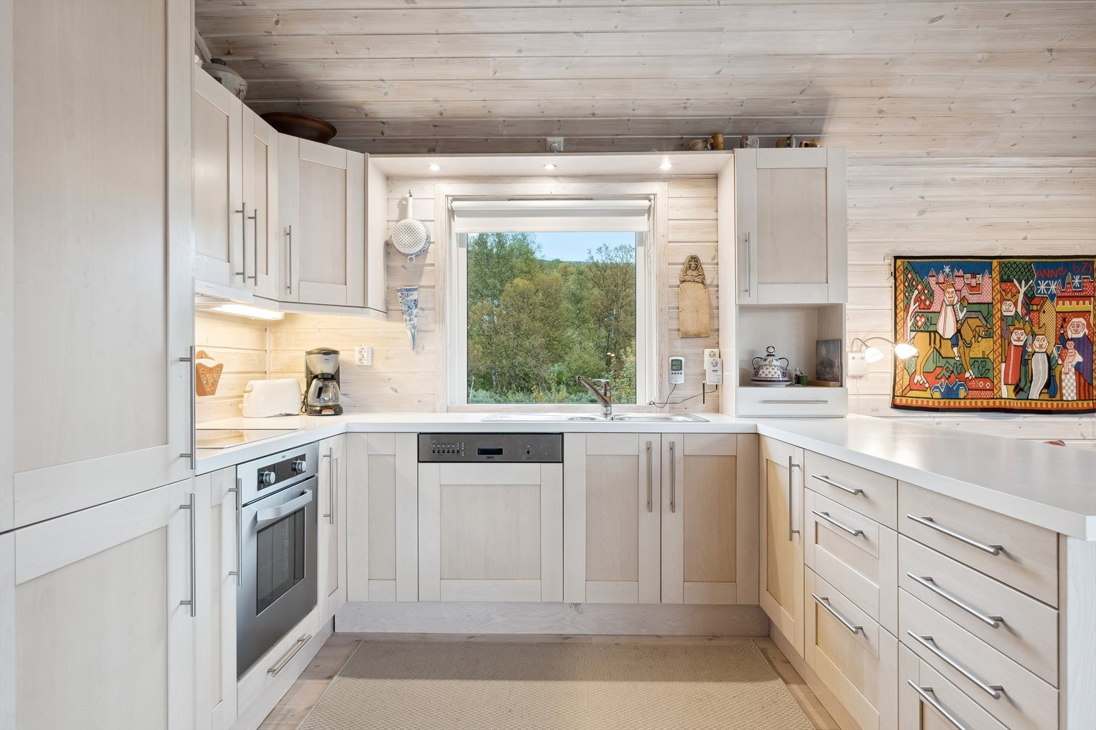 Benkeplaten er av laminat. Det er kjøl/fryseskap, oppvaskmaskin, induksjonstopp og stekeovn. Galleribilde