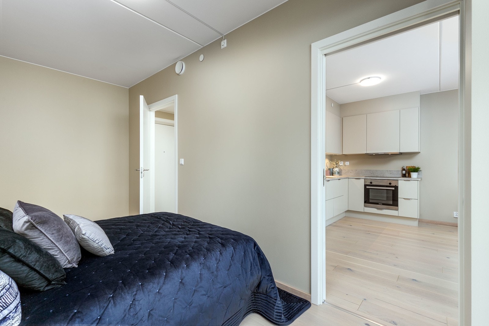 Soverommet har lysmalte veggflater, hvitpigmentert parkett på gulv og store vindusflater Galleribilde