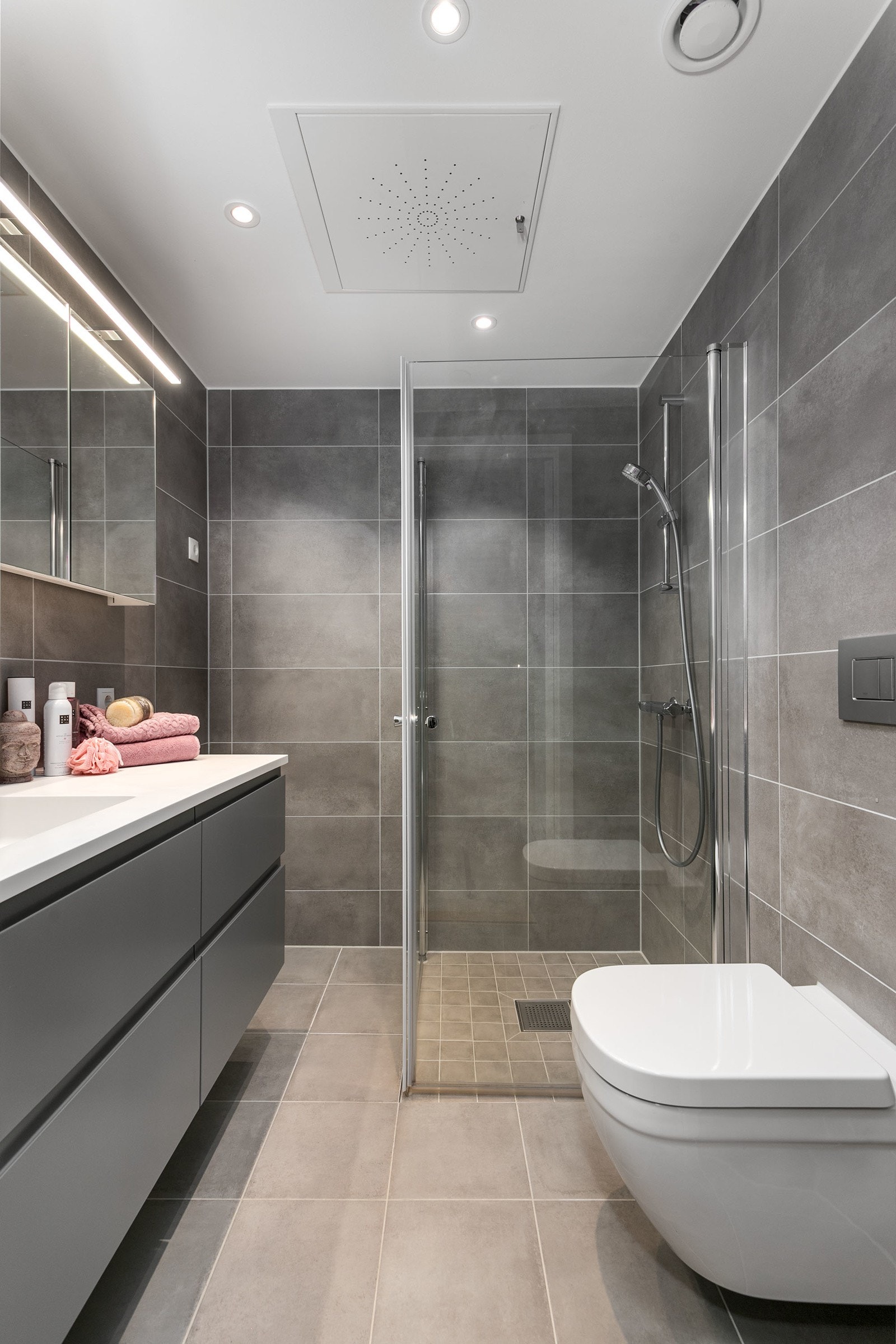 Dusjsone med hånddusj og innfellbare dusjvegger i glass. Himlingen er pent lyssatt med downlights. Det er opplegg for vaskemaskin. Galleribilde