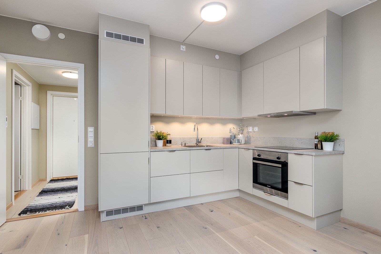 Stilrent kjøkken, nytt i 2023. Kjøkkenet har fint med benke- og arbeidsplass. Innredningen består av slette fronter med foring opp til tak og laminert benkeplate med nedfelt vaskekum i rustfritt stål. Galleribilde