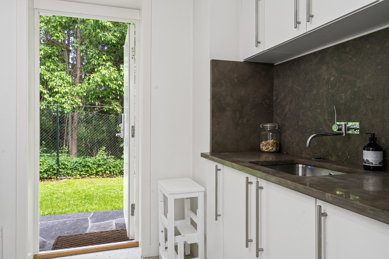 Praktisk kjøkkeninngang, med plassbygget innredning og garderobe fasiliteter. Galleribilde