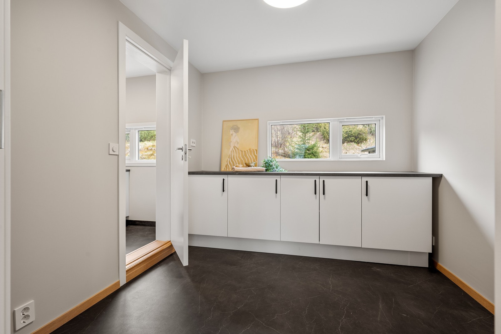 Det er et grovkjøkken/bod tvers over rommet fra kjøkkenet Galleribilde