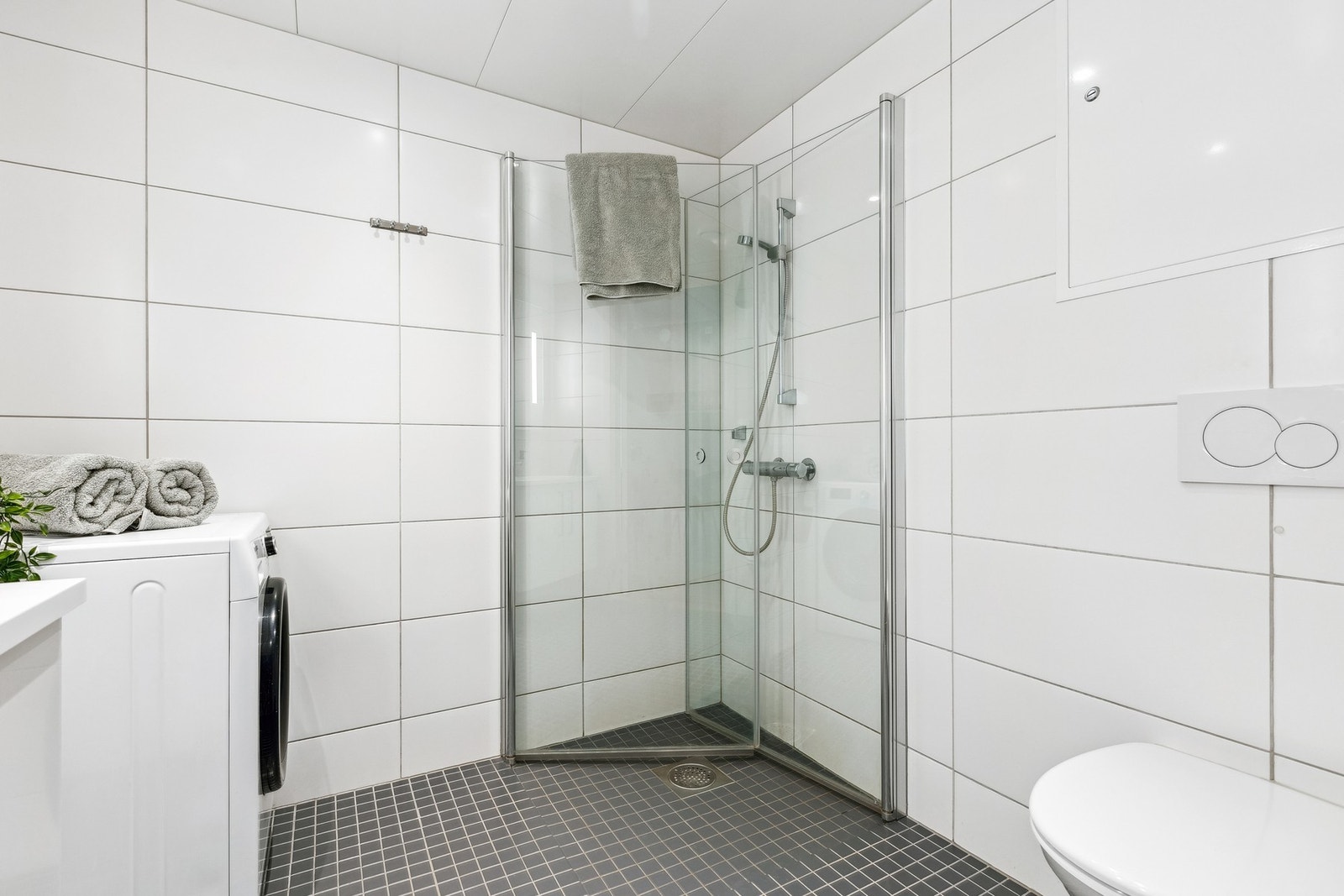 Baderommet måler 4,5 kvm og har dushjørne med dører, samt vegghengt toalett. Galleribilde