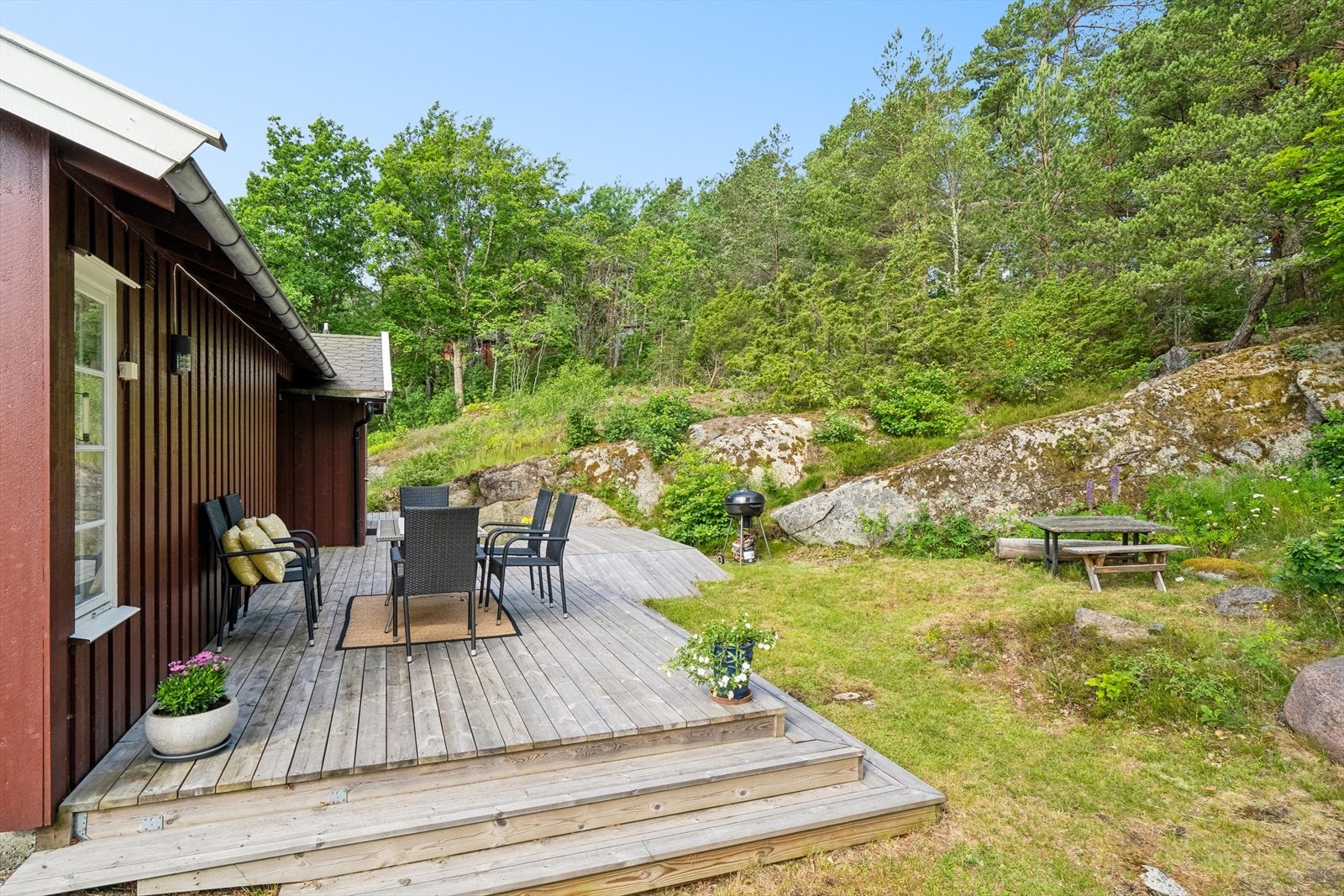 Terrasseplattingen på vestsiden av hytta er pent tilpasset terrenget Galleribilde