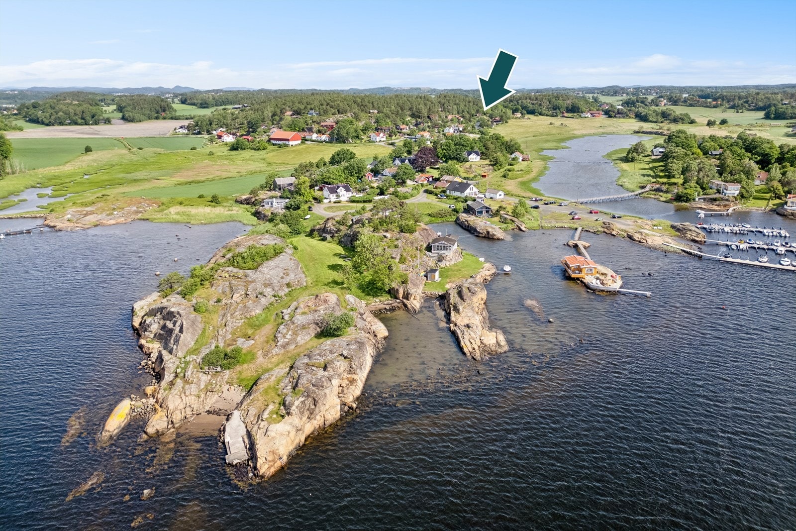 Områdebilde fra Huestranda til venstre og bryggene på Kaupangstranda til høyre. Den grønne pilen viser hyttas plassering Galleribilde