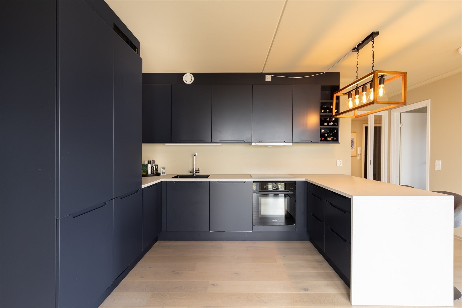 Kjøkkeninnredningen fra HTH har påkostede fronter, påkostet benkeplate som også er videreført ned til gulv i enden av kjøkkendisken, ekstra hylle i innredning og et skjult skap ved disken med eikefronter som en pen kontrast. Galleribilde