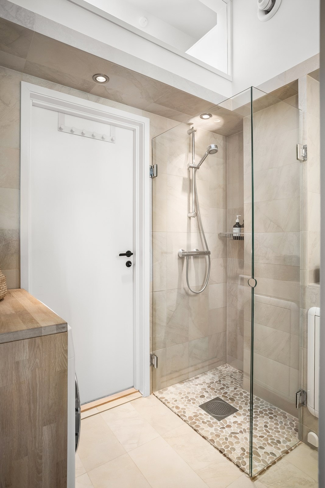 Rullesten på gulv i dusjnisje og innfellbare glassdører. Galleribilde