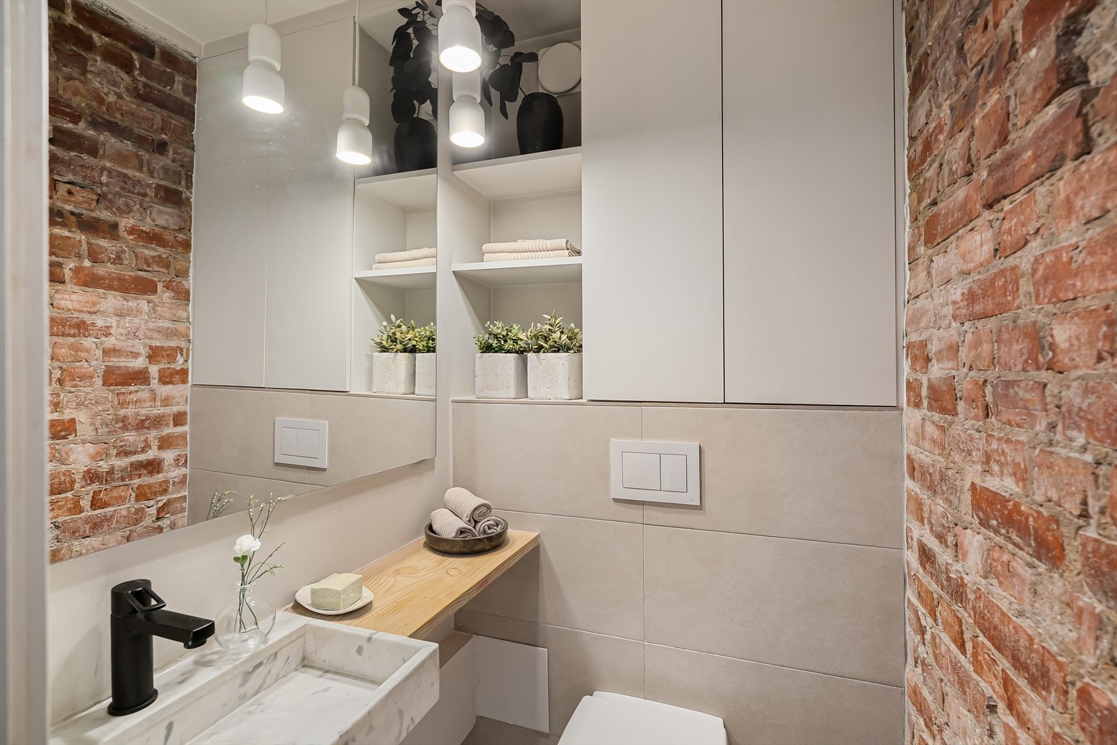 Toalettrom med flis, malt overflate og synlig tegelstens vegger Galleribilde