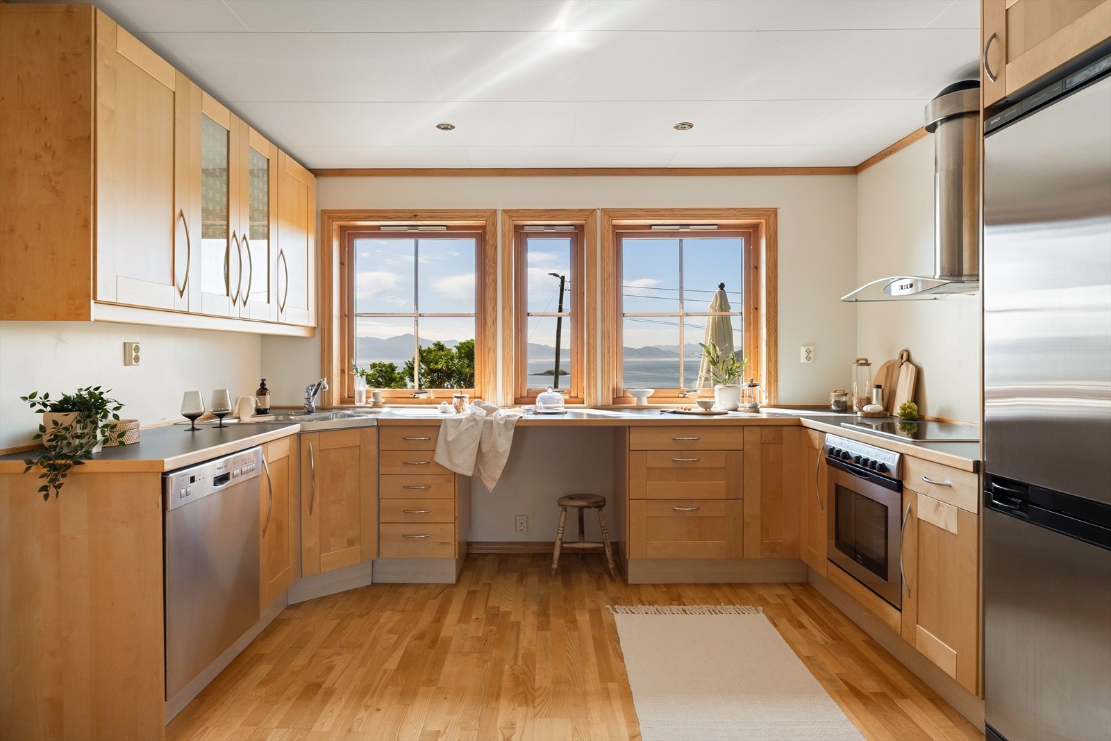 Kjøkkeninnredning med profilerte froner, benkeplate av laminat og stålvask med skyllekum og avrenningsbrett. Galleribilde