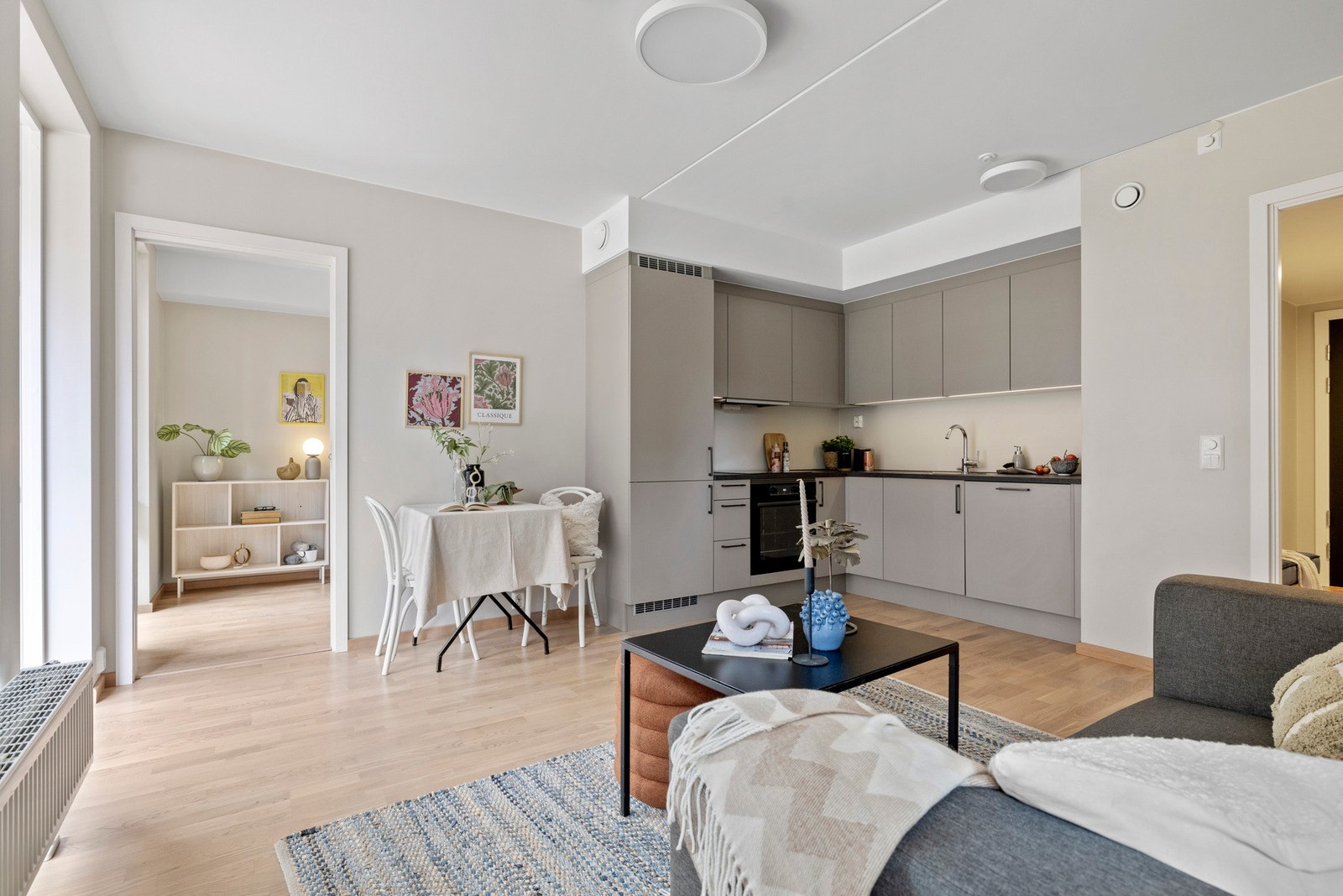 Stue og kjøkken i åpen løsning med naturlig plass for sofa- og spisegruppe. Galleribilde