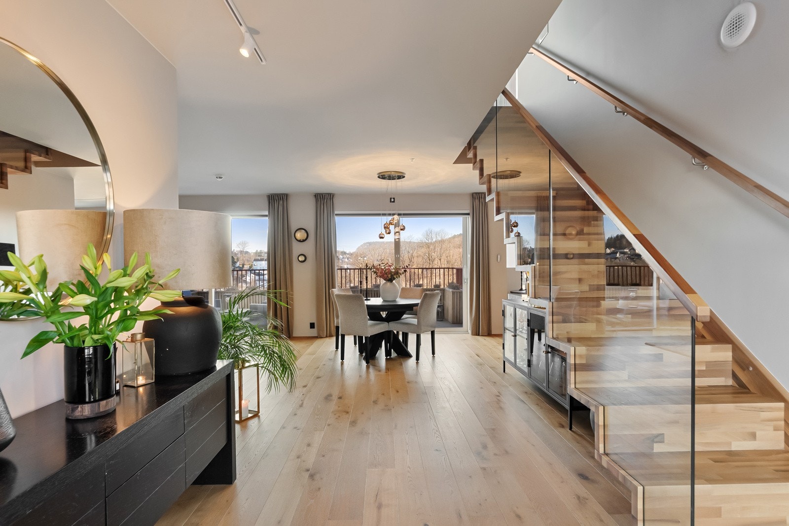 En stilig trapp med fritthengende eiketrinn og rekkverk i glass fører opp til loftstuen. Galleribilde