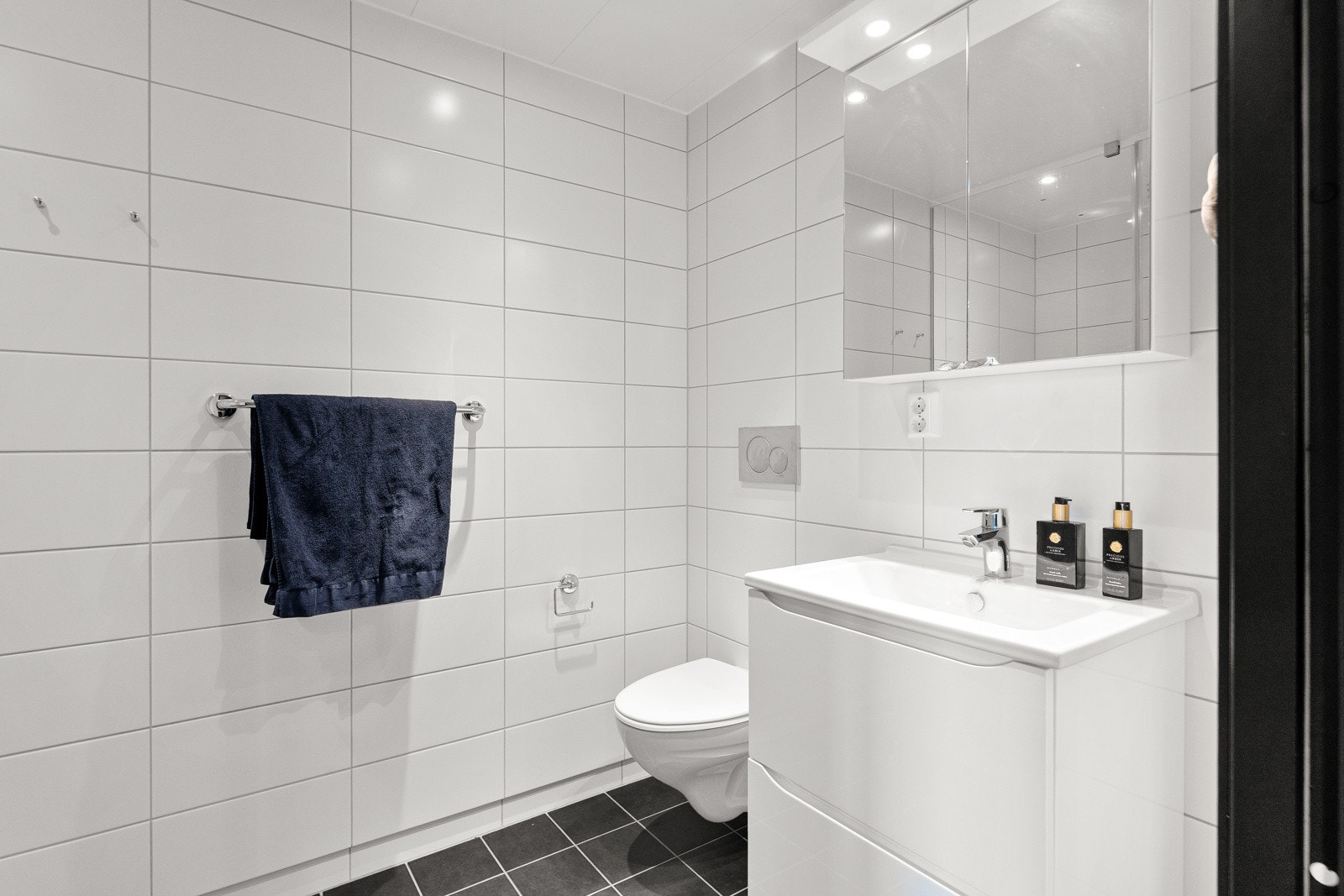 Badet i toppetasjen har inngang fra loftstuen. Lun gulvvarme, lys innredning og romslig dusjhjørne også her. Galleribilde