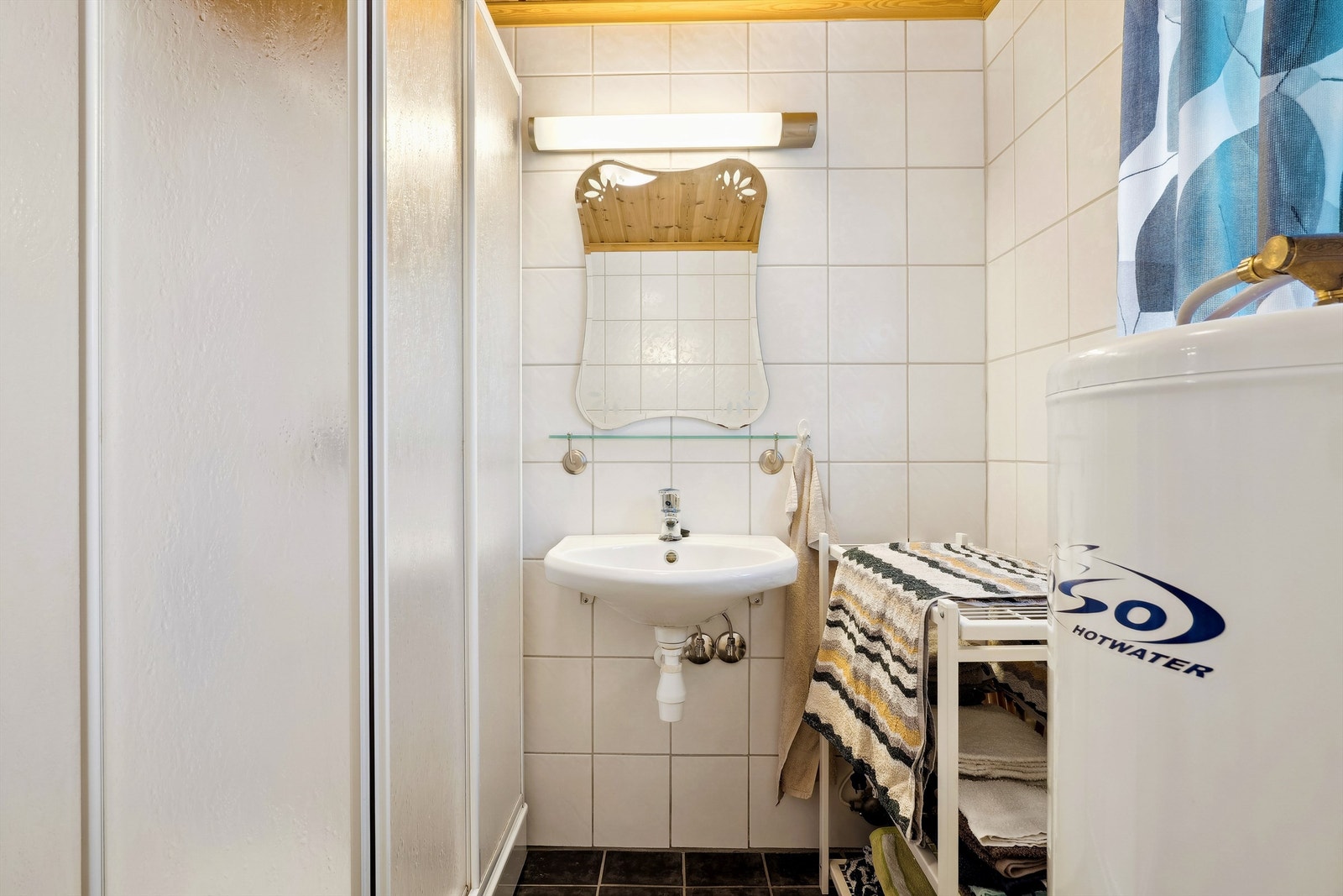 Bad med fliser og varmekabler på gulv, fliser på vegger og panel i himling. Galleribilde