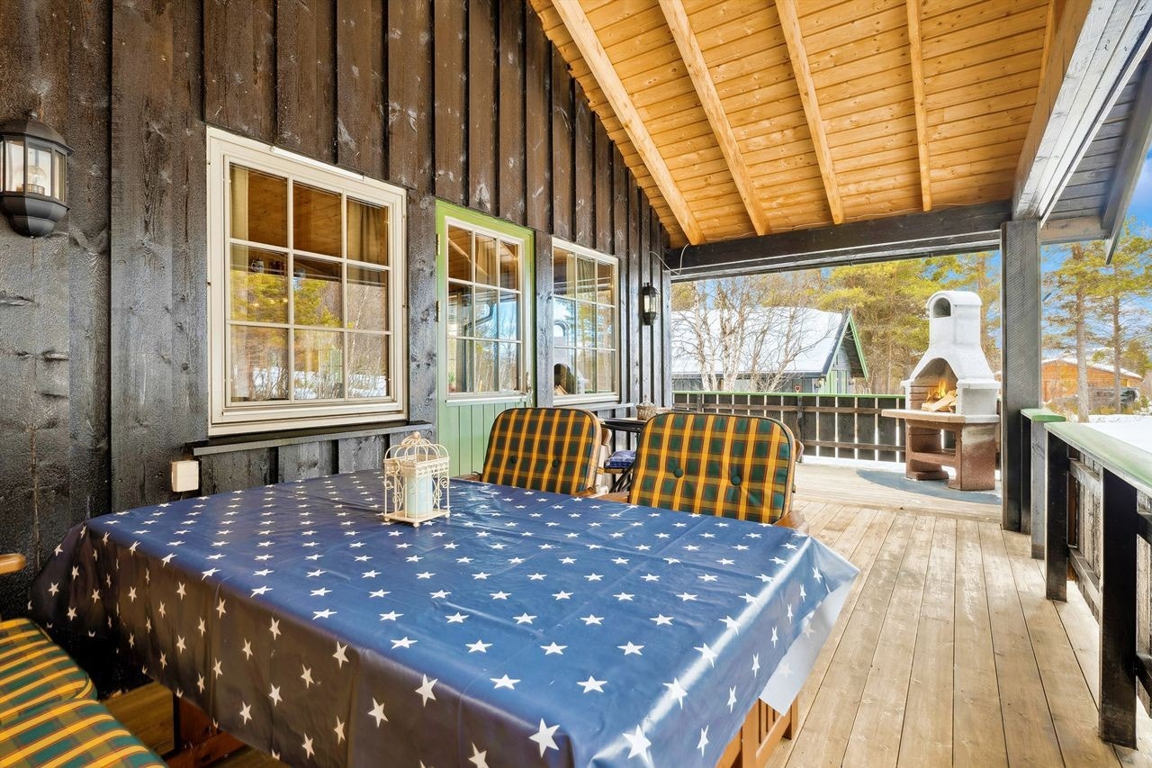 Utgang fra stuen til delvis overbygd veranda med god plass for hagemøblement. Galleribilde