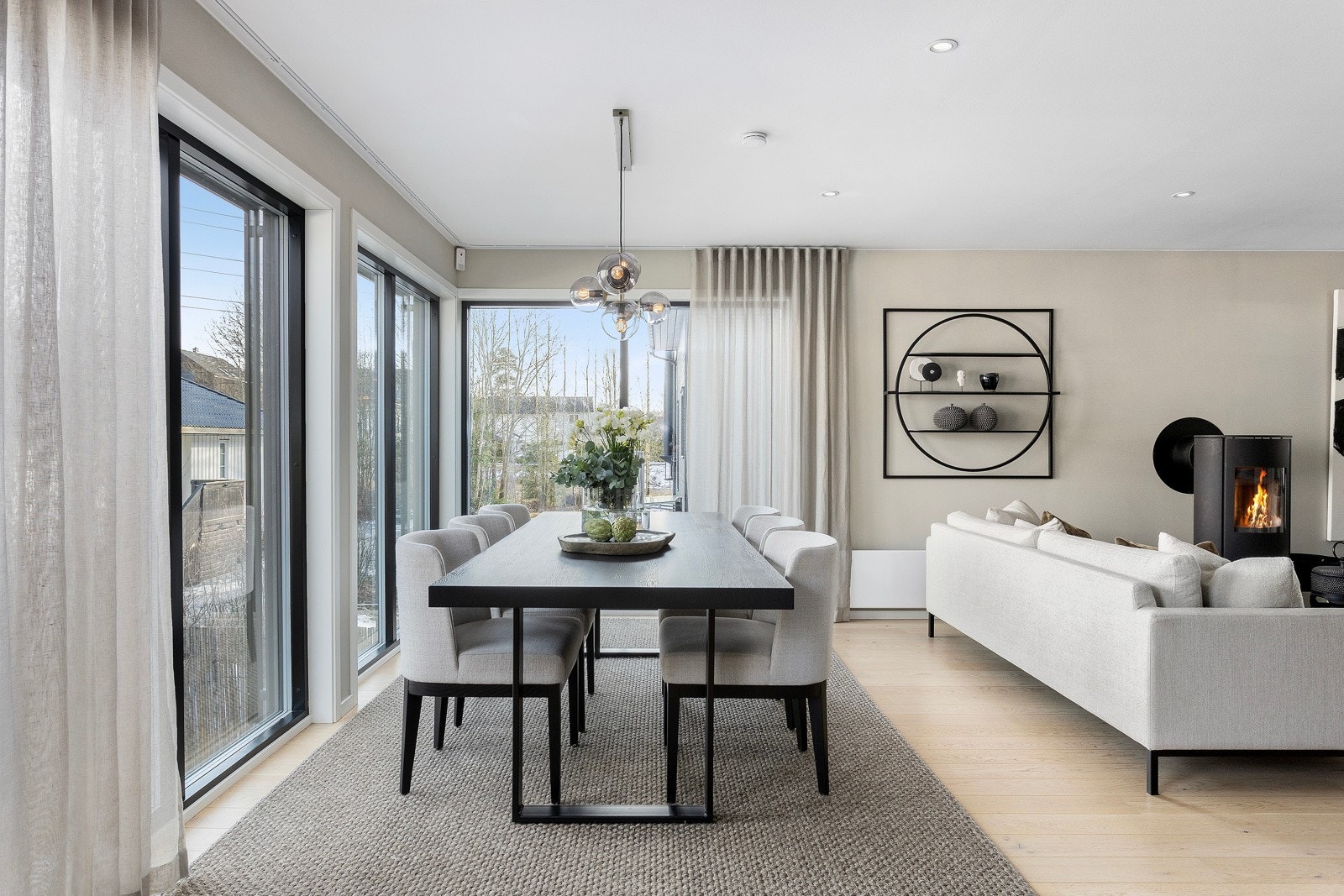 Det sosiale oppholdsrommet har enstavs parkett på gulvet, beige-toner på veggene og utstrakt bruk av downlightsbelysning med dimmer. Galleribilde