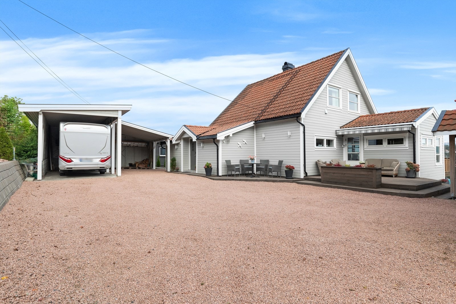 Stor gårdsplass med carport, dobbelgarasje og god oppstillingsplass i gruset gårdsplass Galleribilde