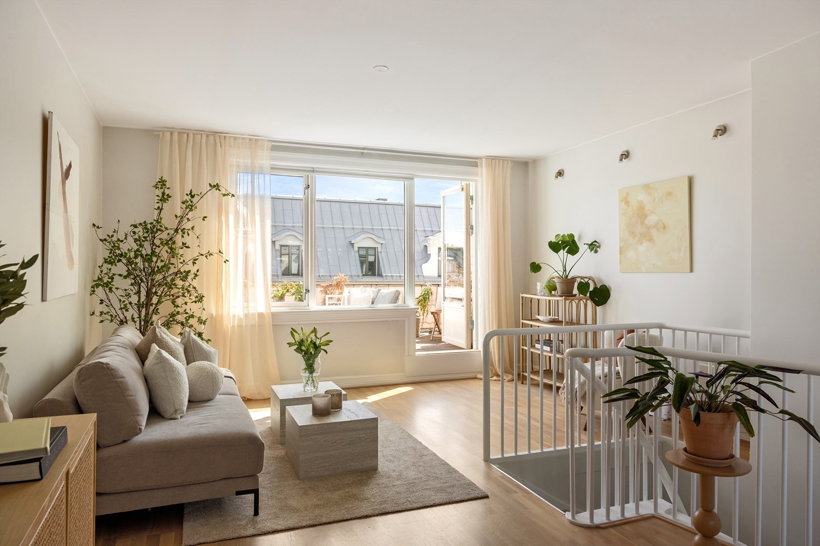 Lys og pen stue med plass til en større sofa, salongbord og annet møblement Galleribilde