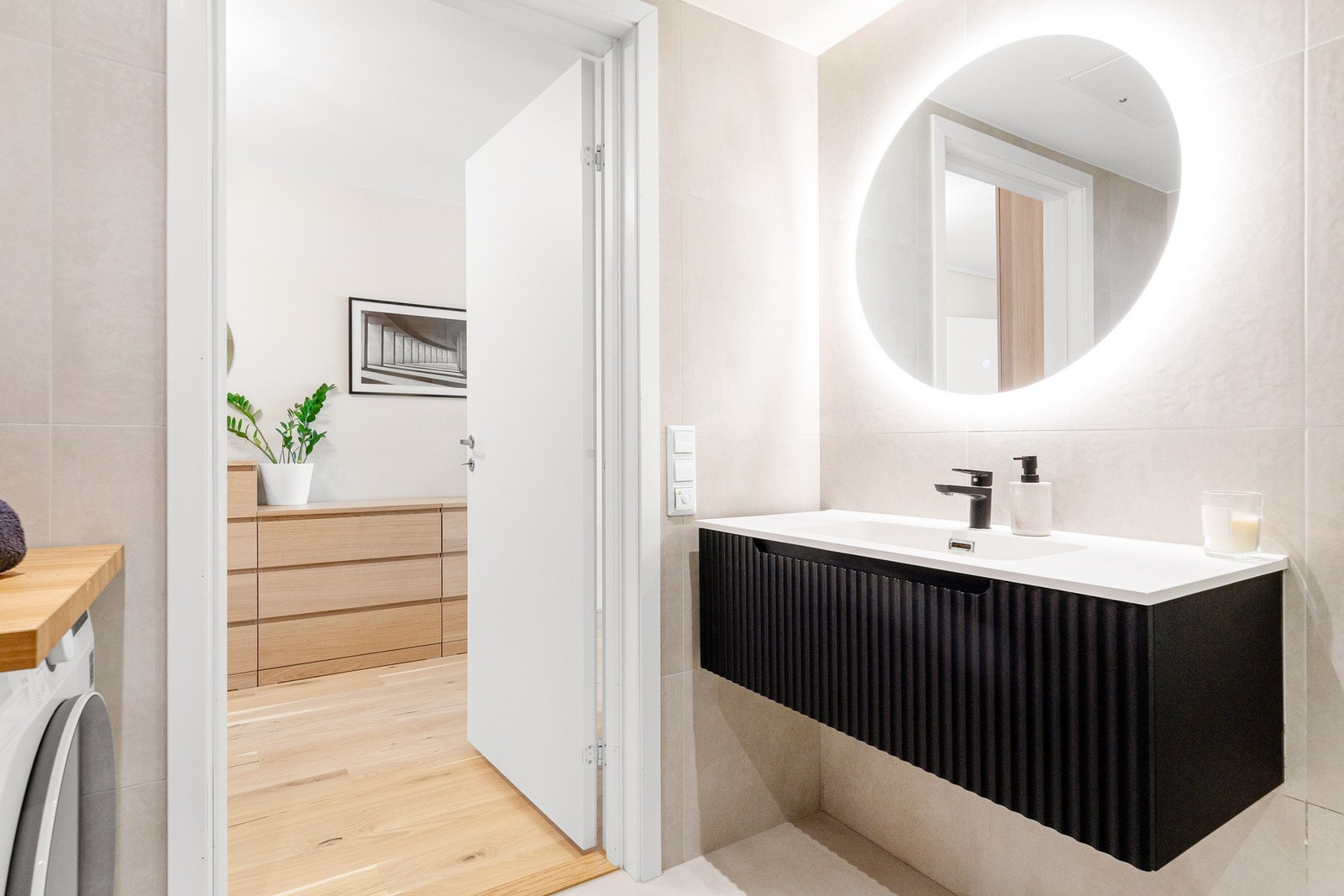 Badet er innredet med servantseksjon med skuffer, dusjhjørne og vegghengt toalett. Galleribilde