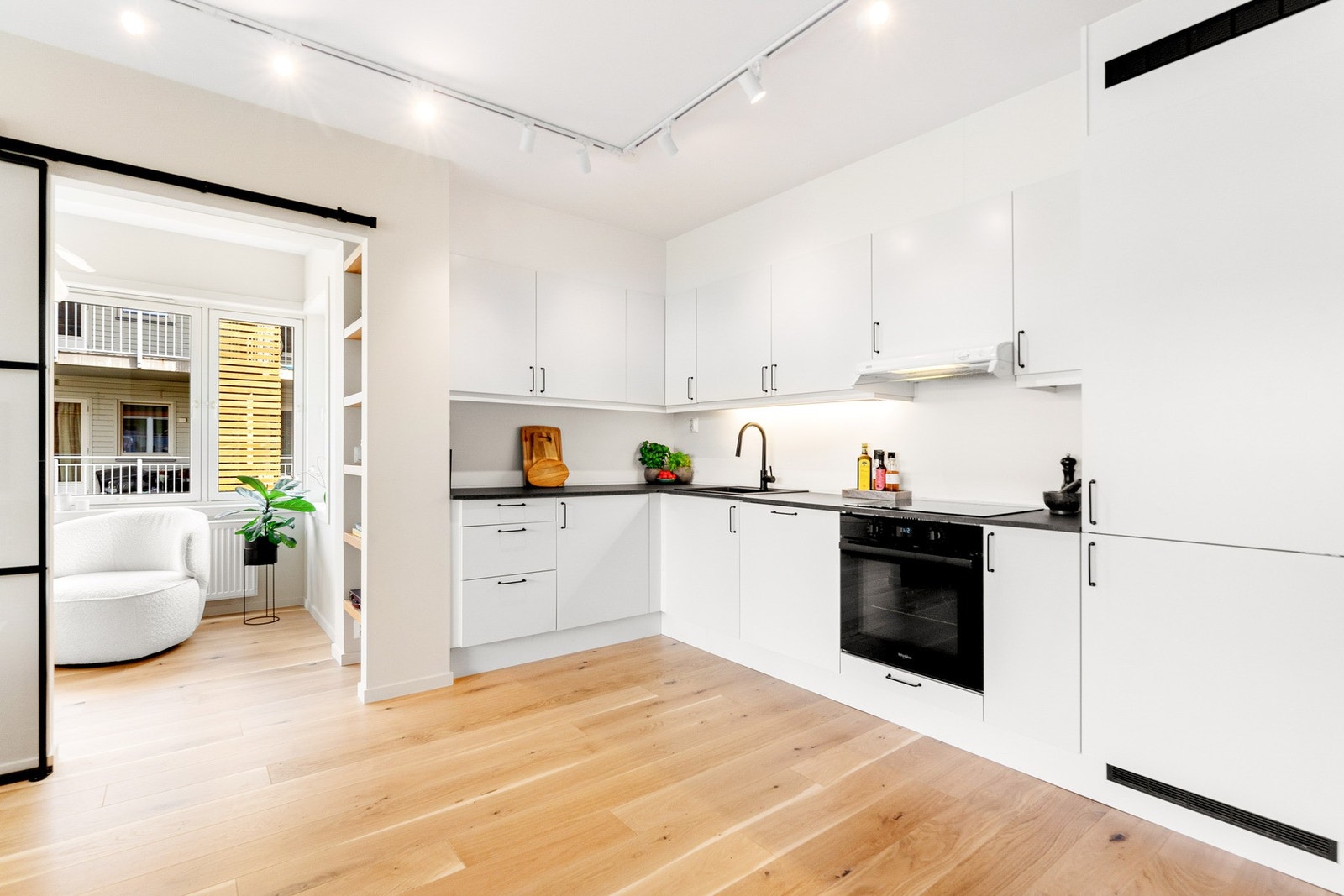 Pen og moderne kjøkkeninnredning med slette fronter og benkeplate i laminat. Galleribilde