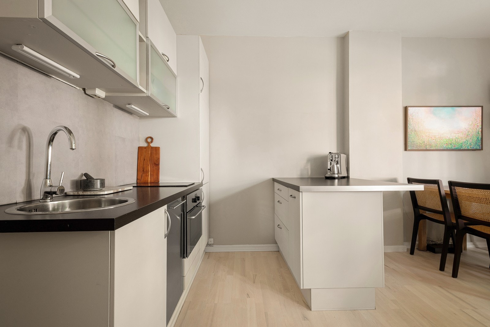 Åpen stue/kjøkkenløsning med praktisk kjøkkenøy, som gir ekstra benkeplass Galleribilde