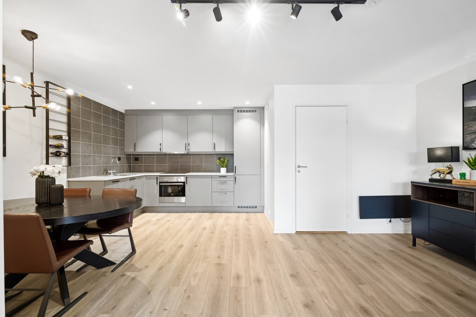 Selv med åpen løsning mellom stue og kjøkken, oppleves kjøkkenet som en egen, skjermet del av boligen takket være stuens størrelse. Galleribilde