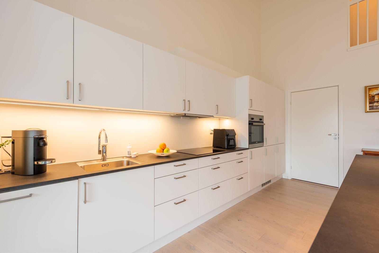 Sigdal kjøkken med hvite slette fronter og laminat benkeplate. Galleribilde