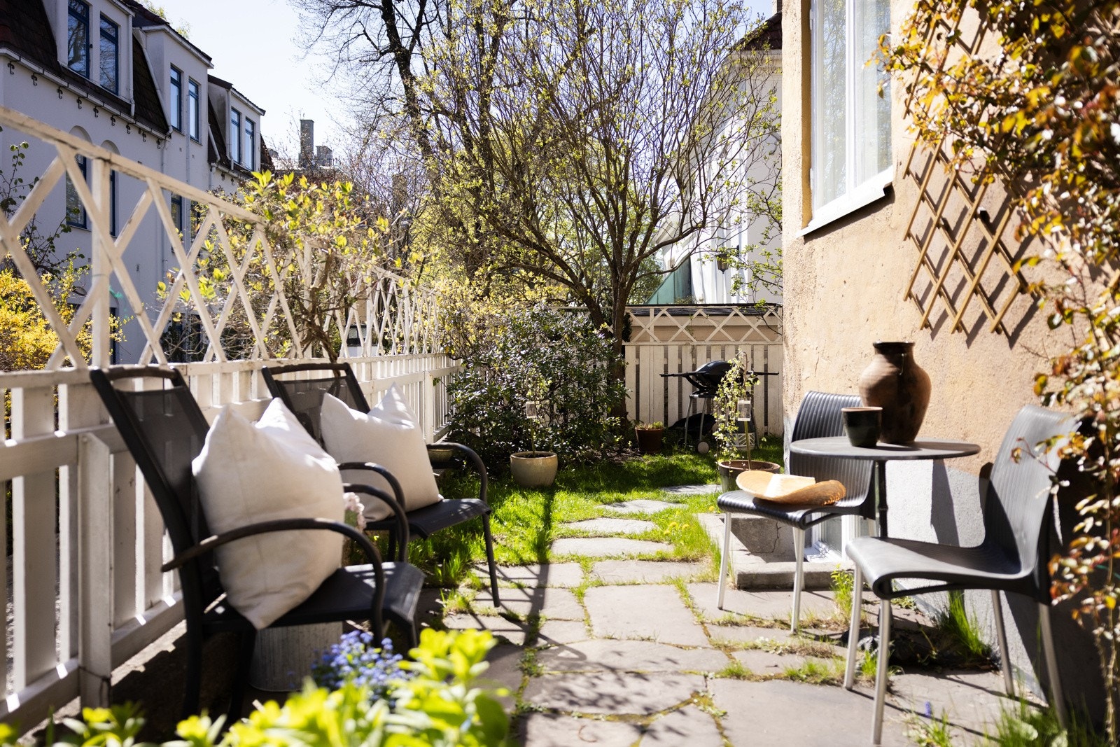 Intim og skjermet hageflekk med sittegruppe og frodig beplantning Galleribilde