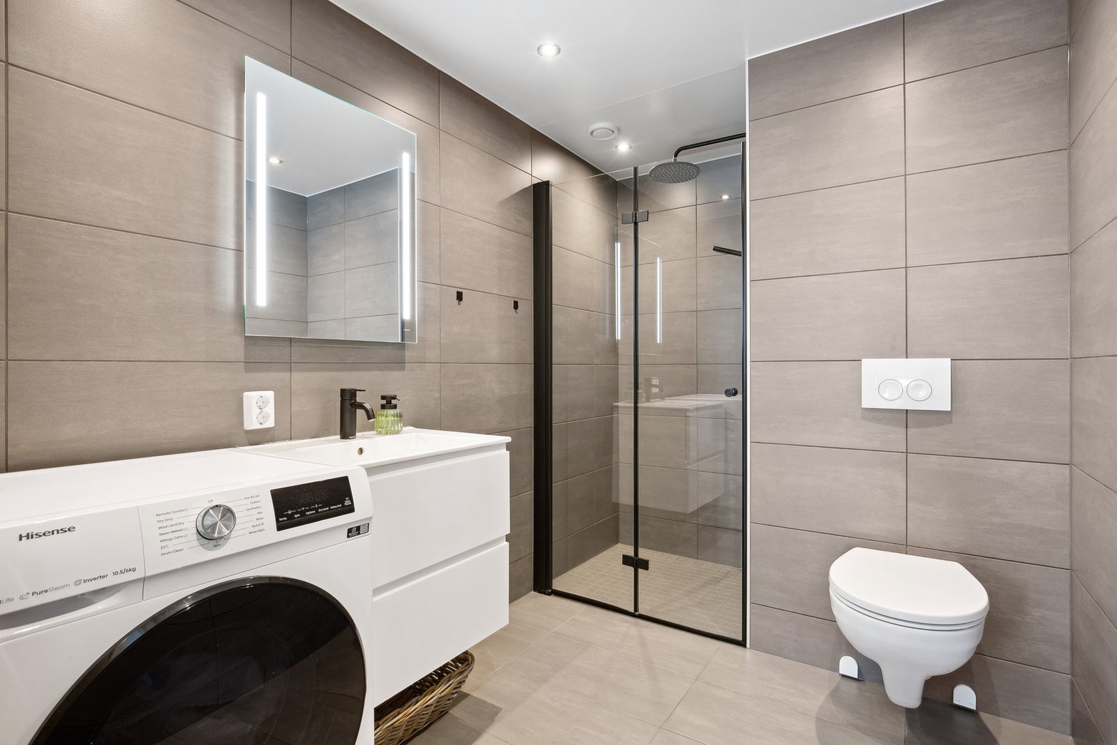 Flislagt flott bad med innredning og nedfelt servant, vegghengt wc og dusjnisje Galleribilde