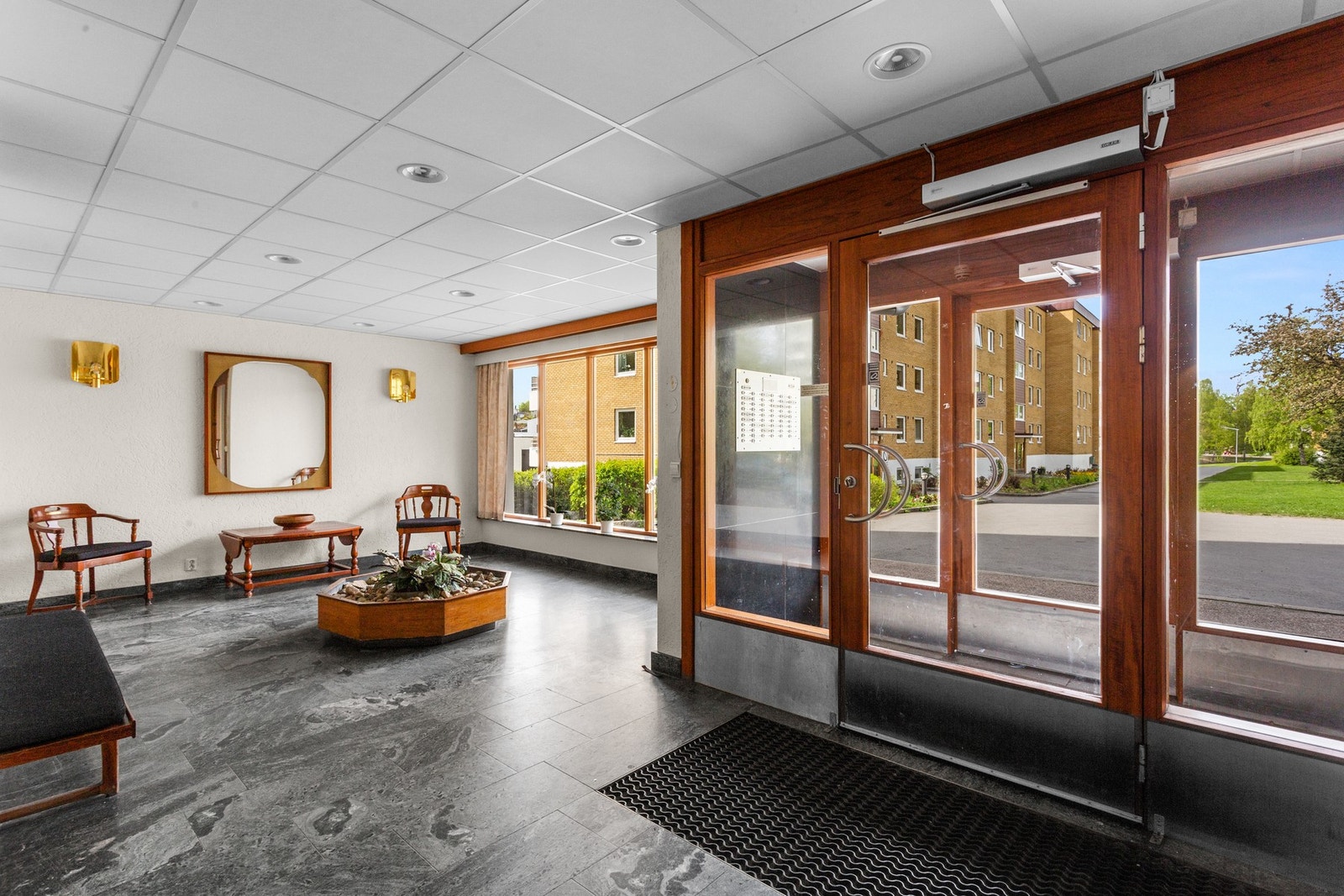 Blokken har et hyggelig inngangsparti, og det er heisadkomst opp til leilighetsplanet. Pent beplantet utenfor. Galleribilde