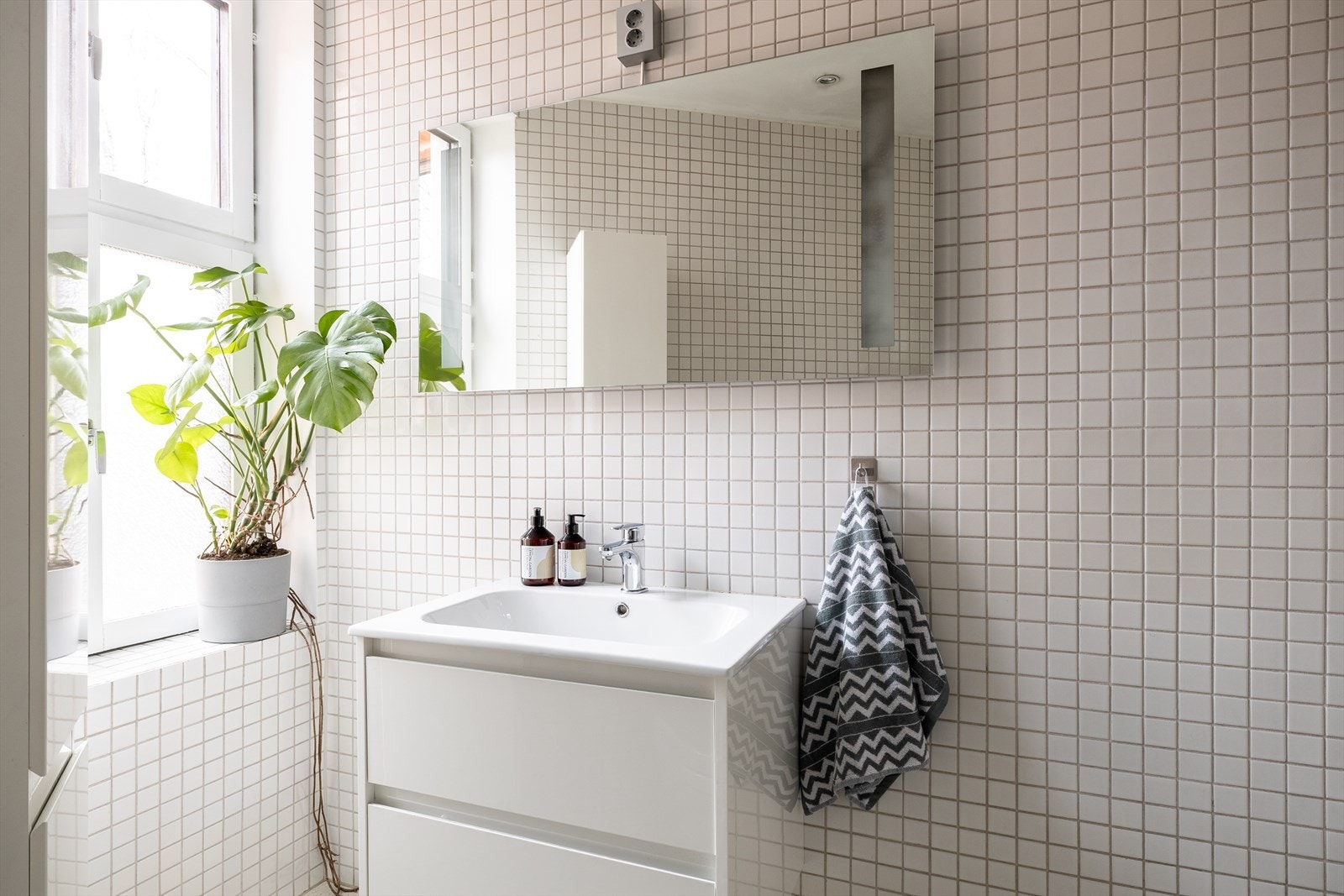 Badet er innredet med veggmontert toalett, servantinnredning og dusjhjørne. Galleribilde