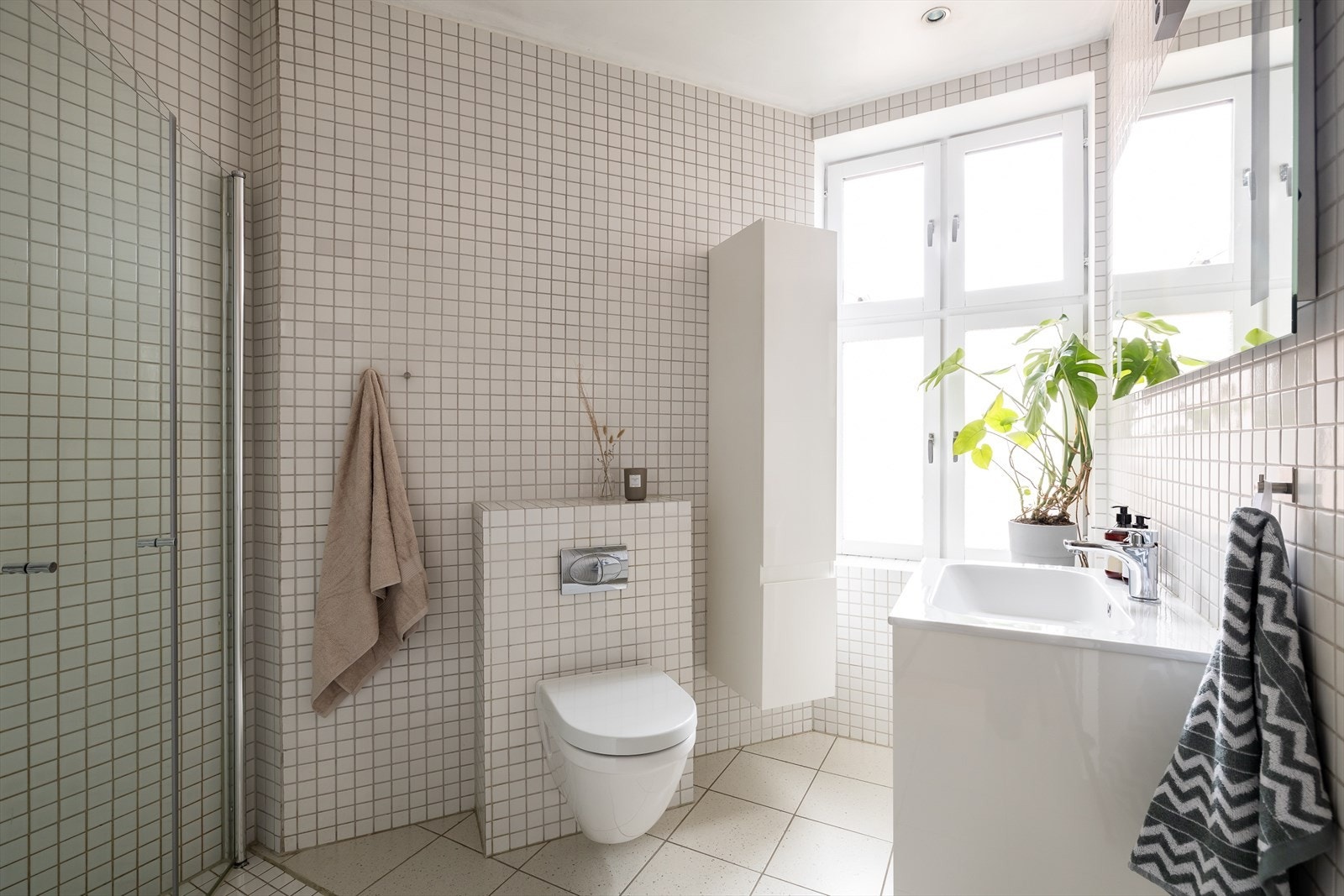 Det arealsmarte badet er lyst flislagt med varmekabler i gulv. Galleribilde