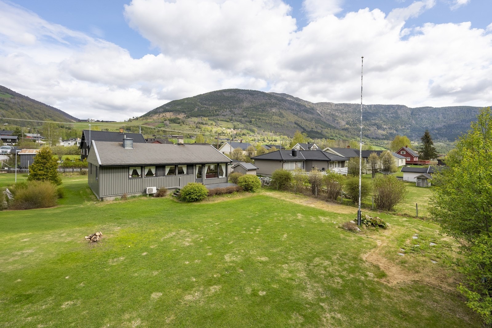 Eiendommen har flaggstang og tomten er gjerdet inn. Galleribilde