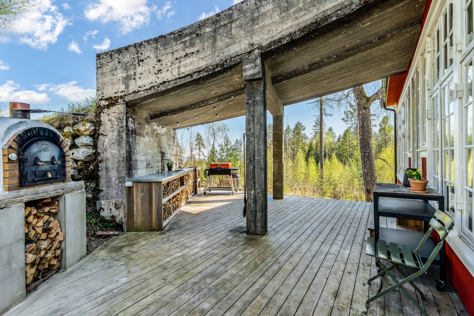 Trerrasse under låvebrua. Her er det laget til ett utekjøkken og med pizzaovn. Galleribilde