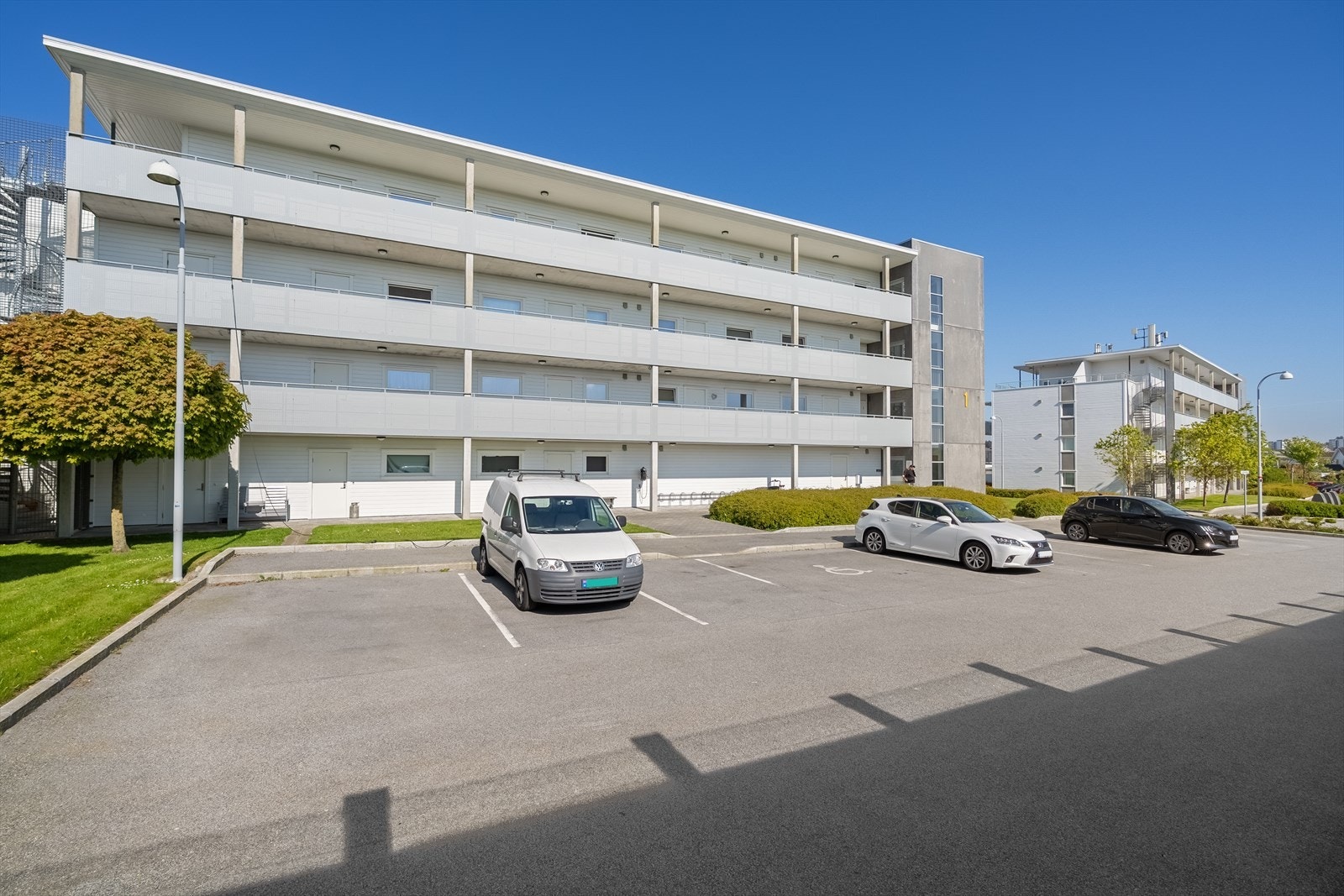 Felles åpen parkeringsplass utenfor blokken. Galleribilde