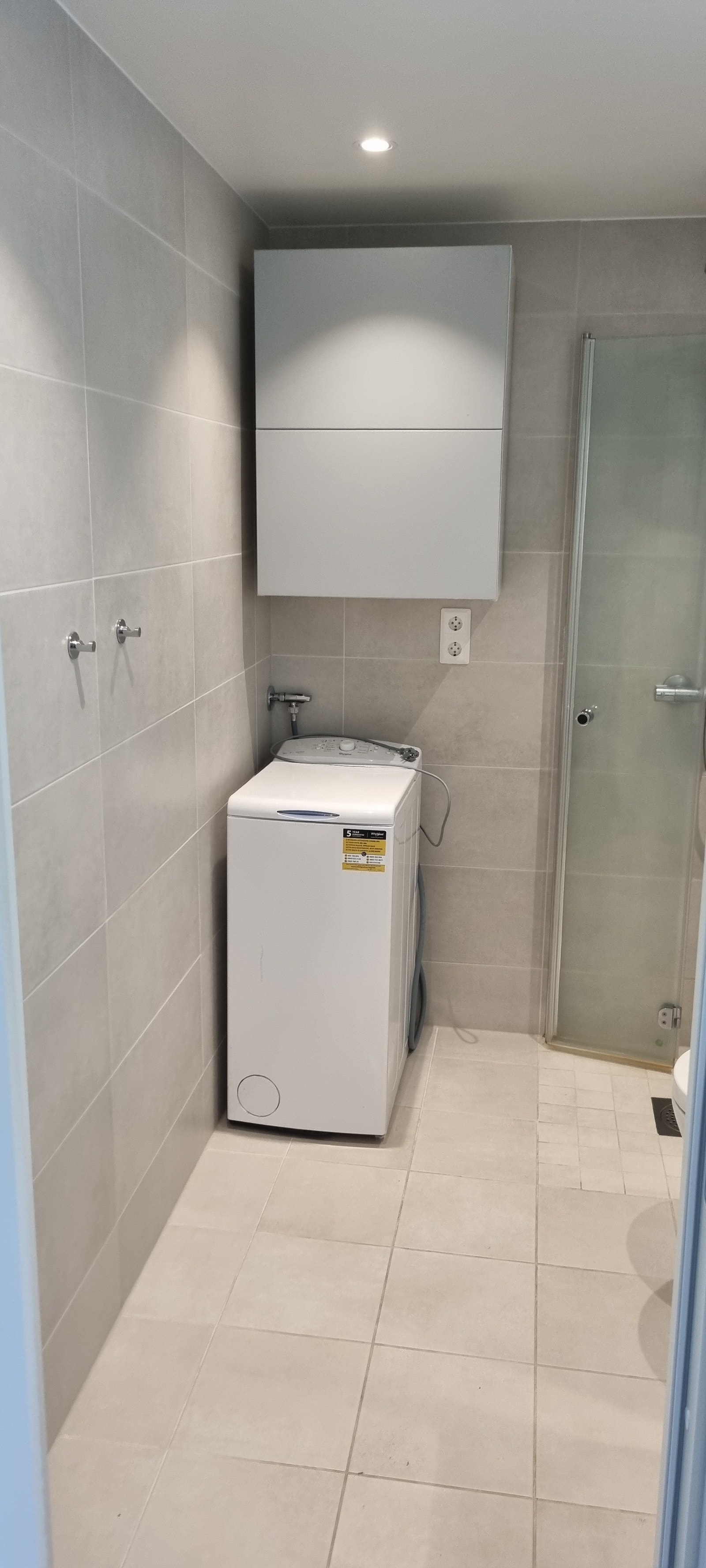 Flislagt bad med vaskemaskin. Galleribilde